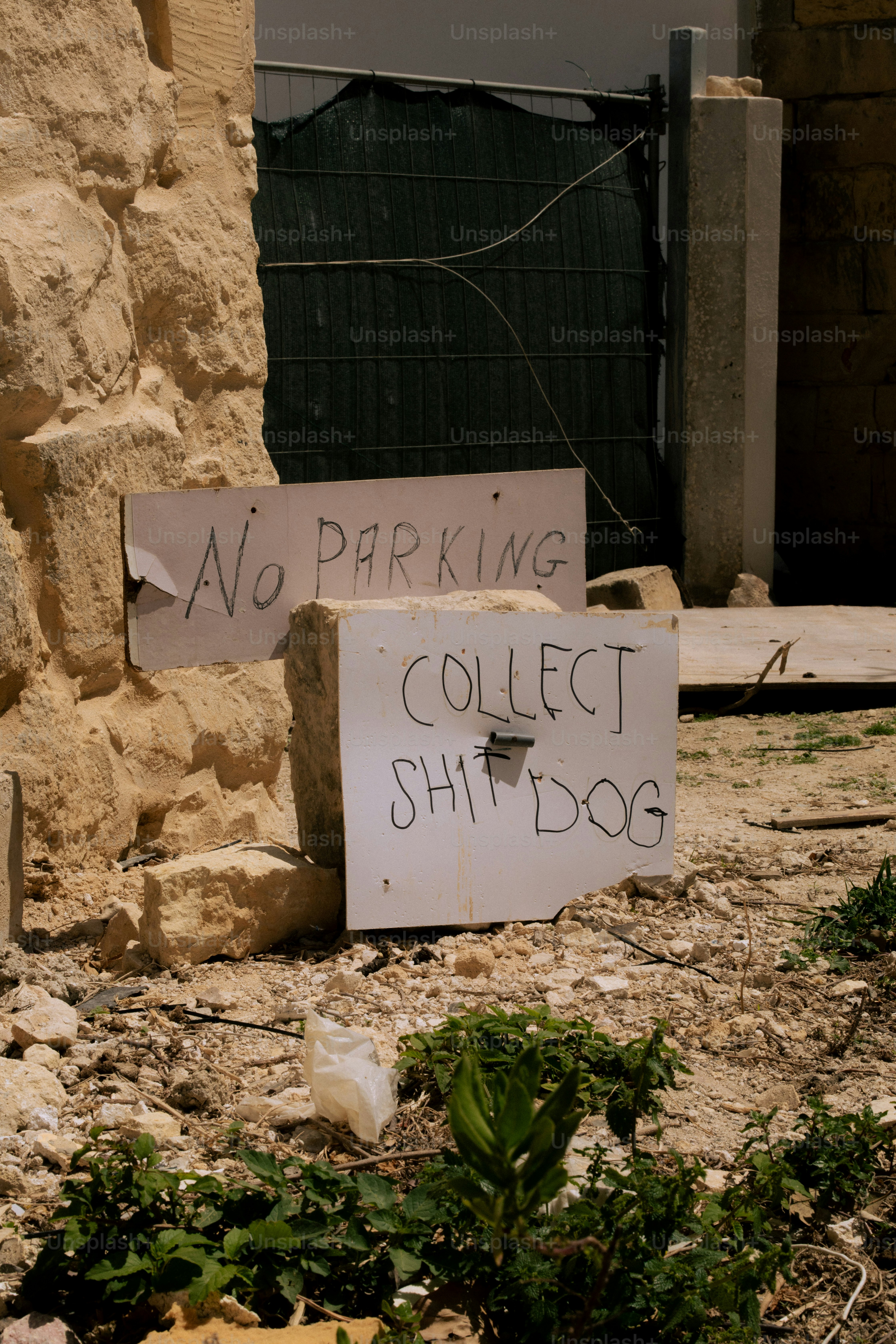 Two handwritten signs about parking and dog waste.