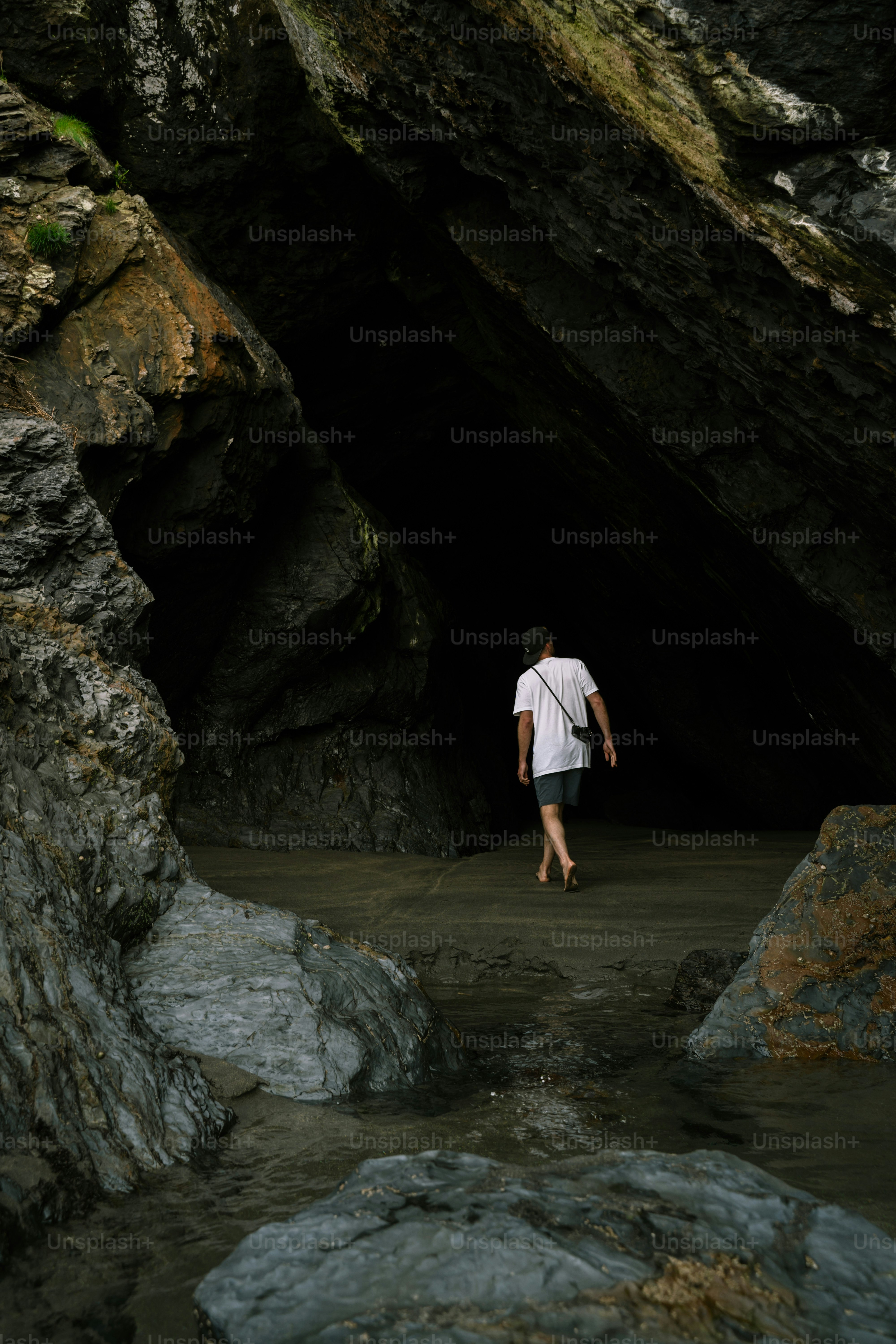 Person walking into a dark cave entrance