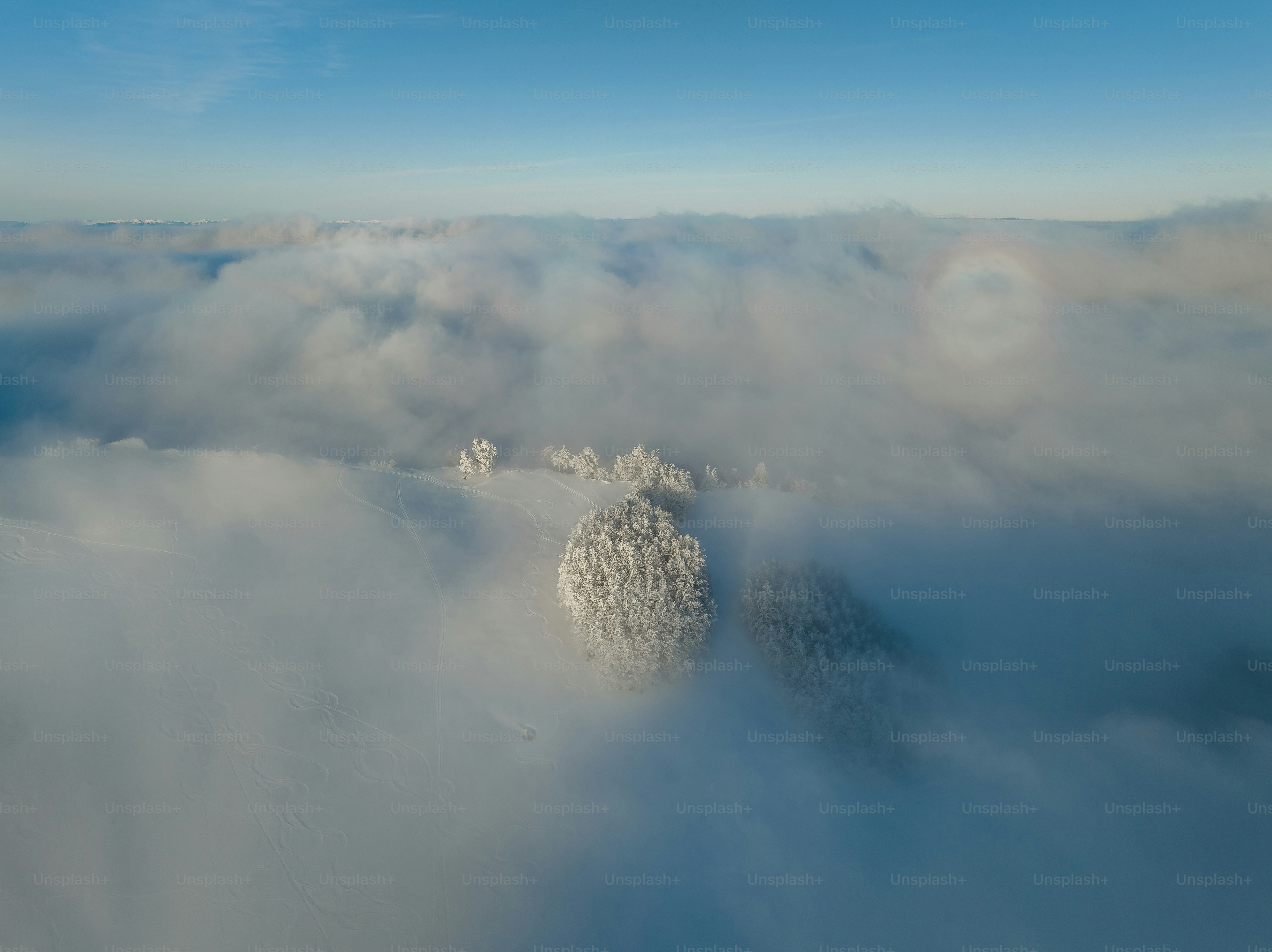 Snow-covered mountain peak emerges from clouds