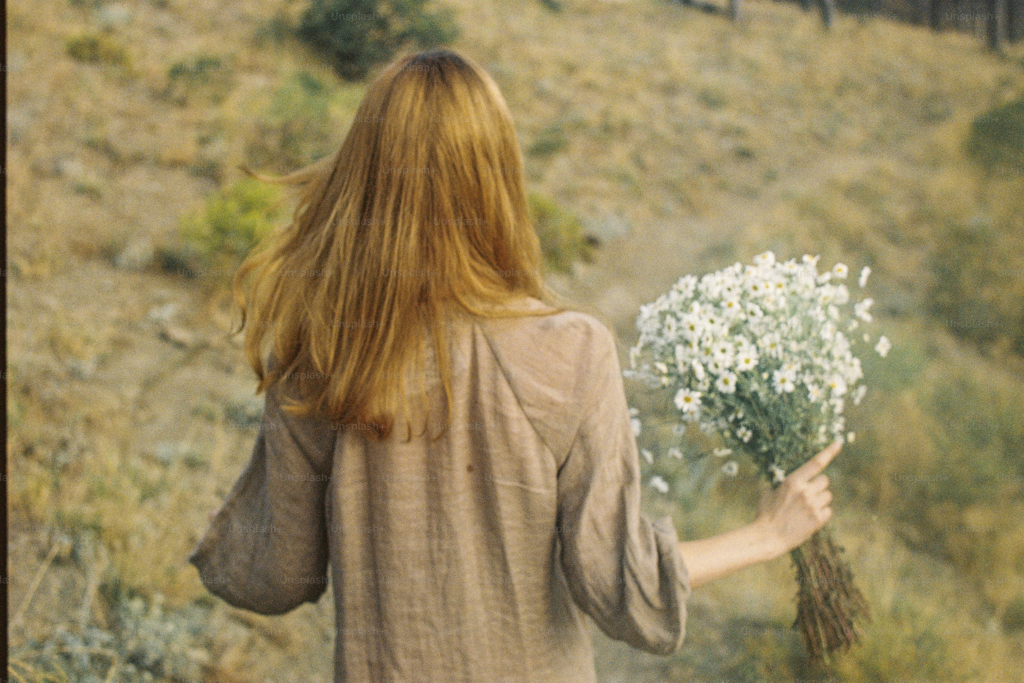 Woman holding a bouquet of white flowers in a field