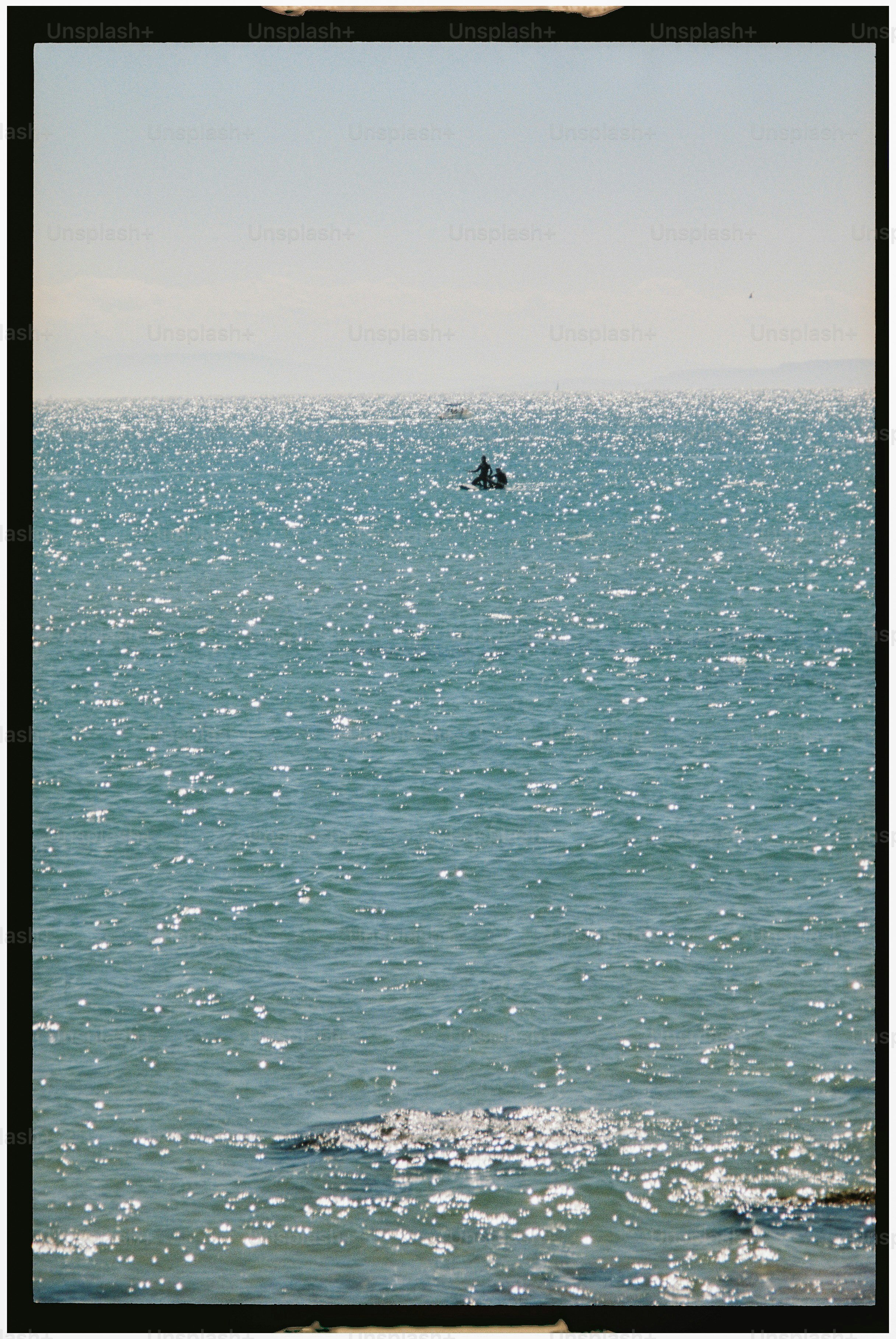 A person kayaking on a sparkling blue ocean