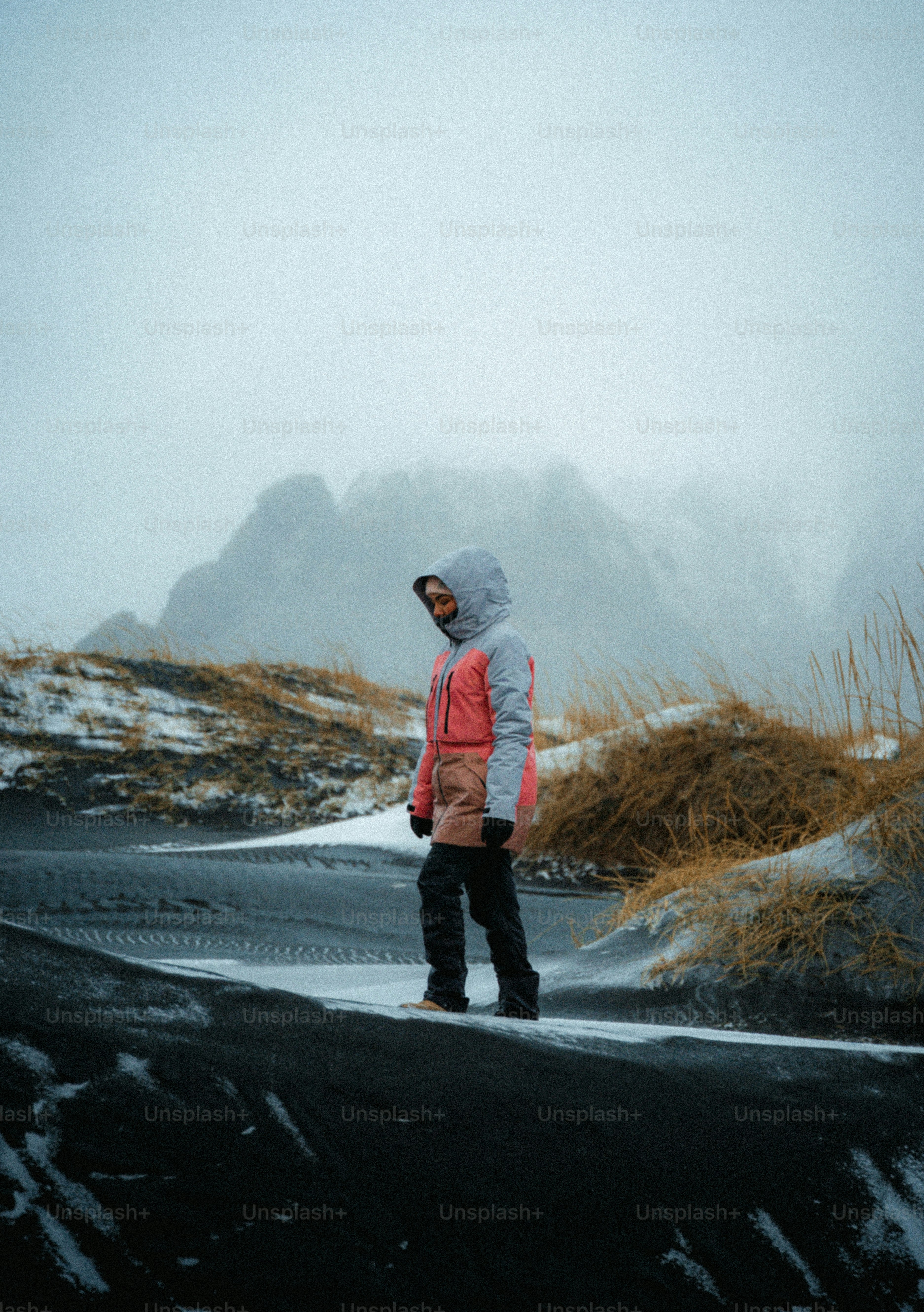 A person stands on a snowy, sandy landscape.