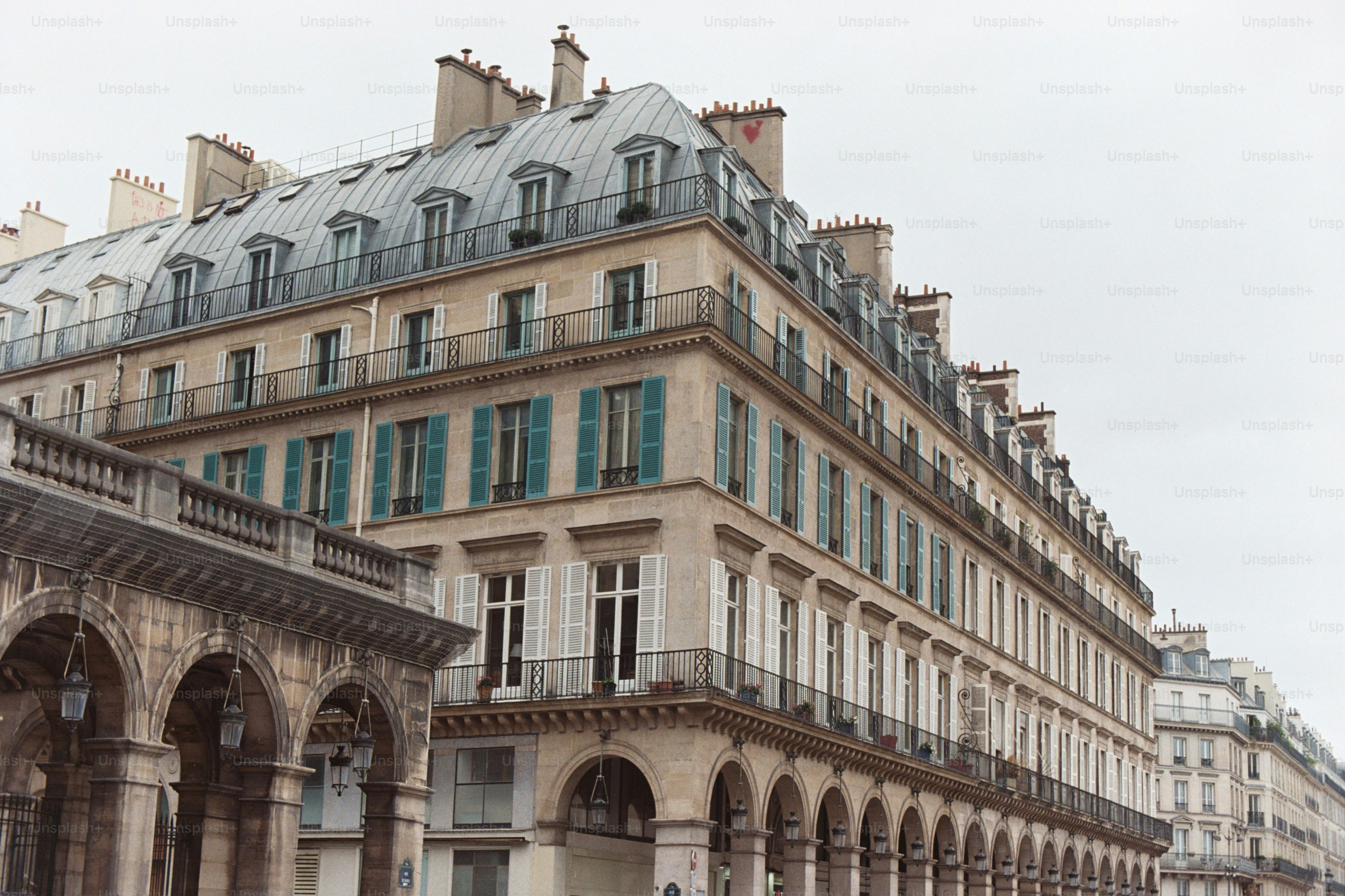 Classic parisian building with mansard roof and arches