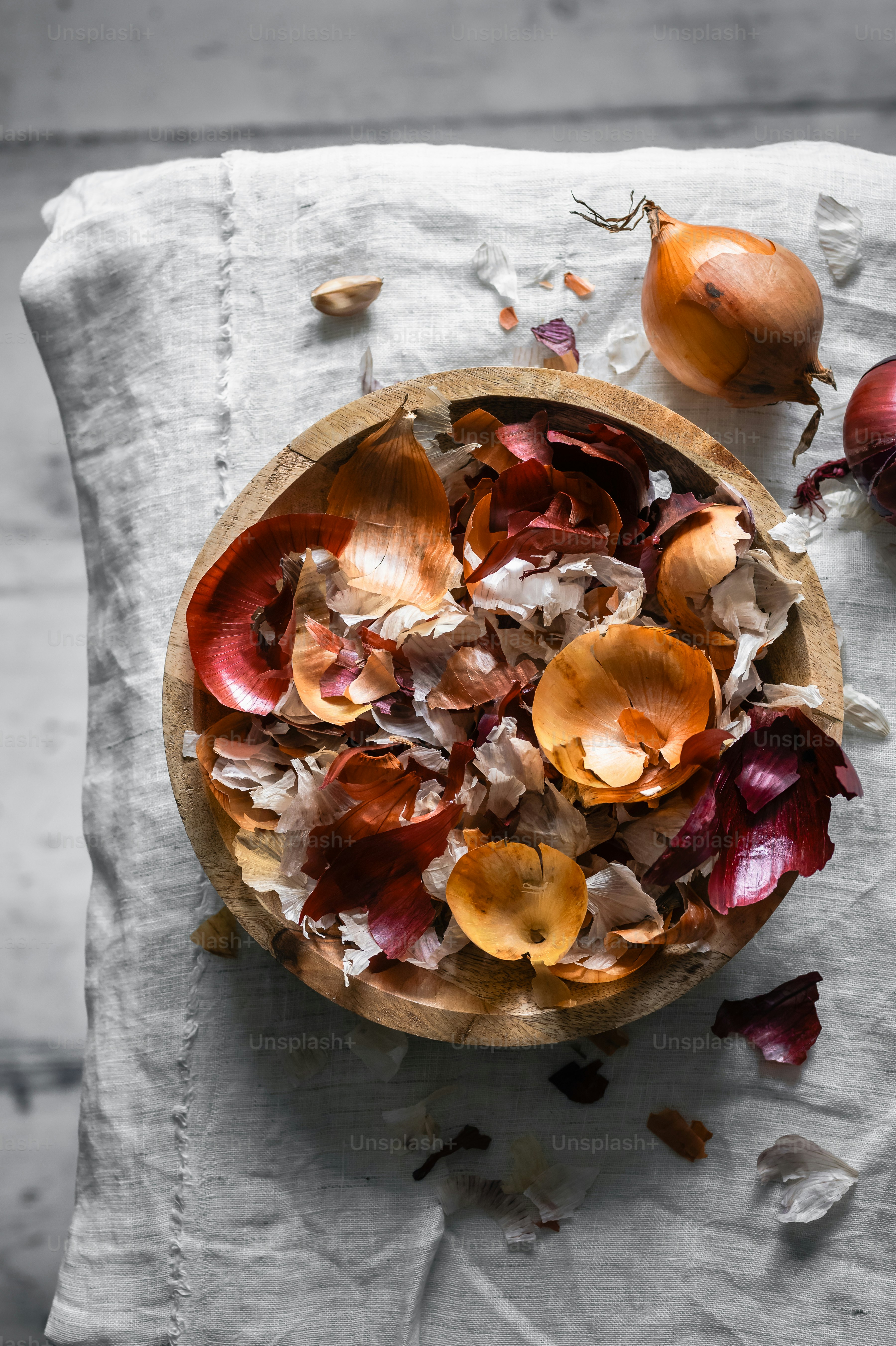 Zwiebelschalen und -reste in einer Holzschale.