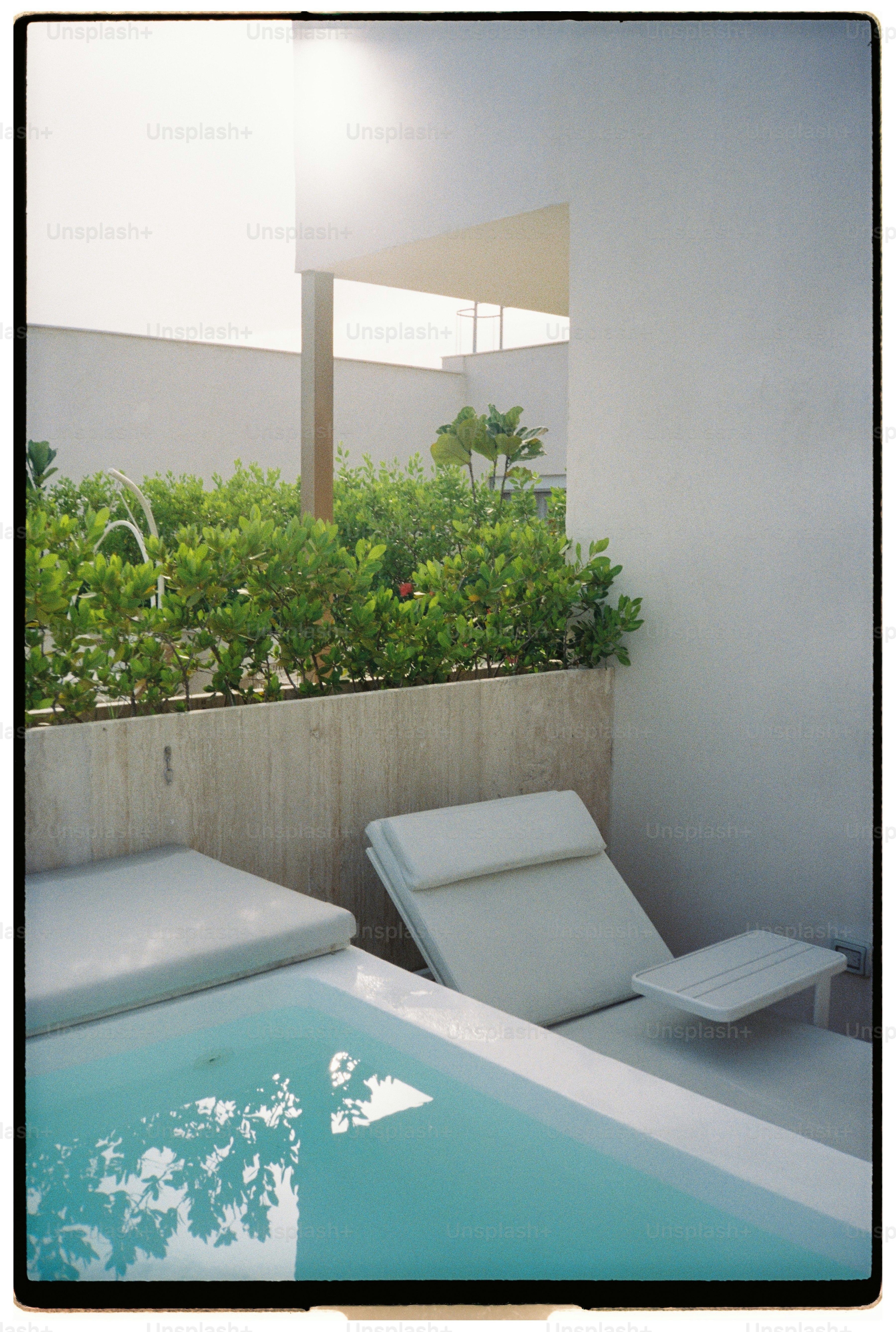 Zwei Liegestühle an einem kleinen Pool