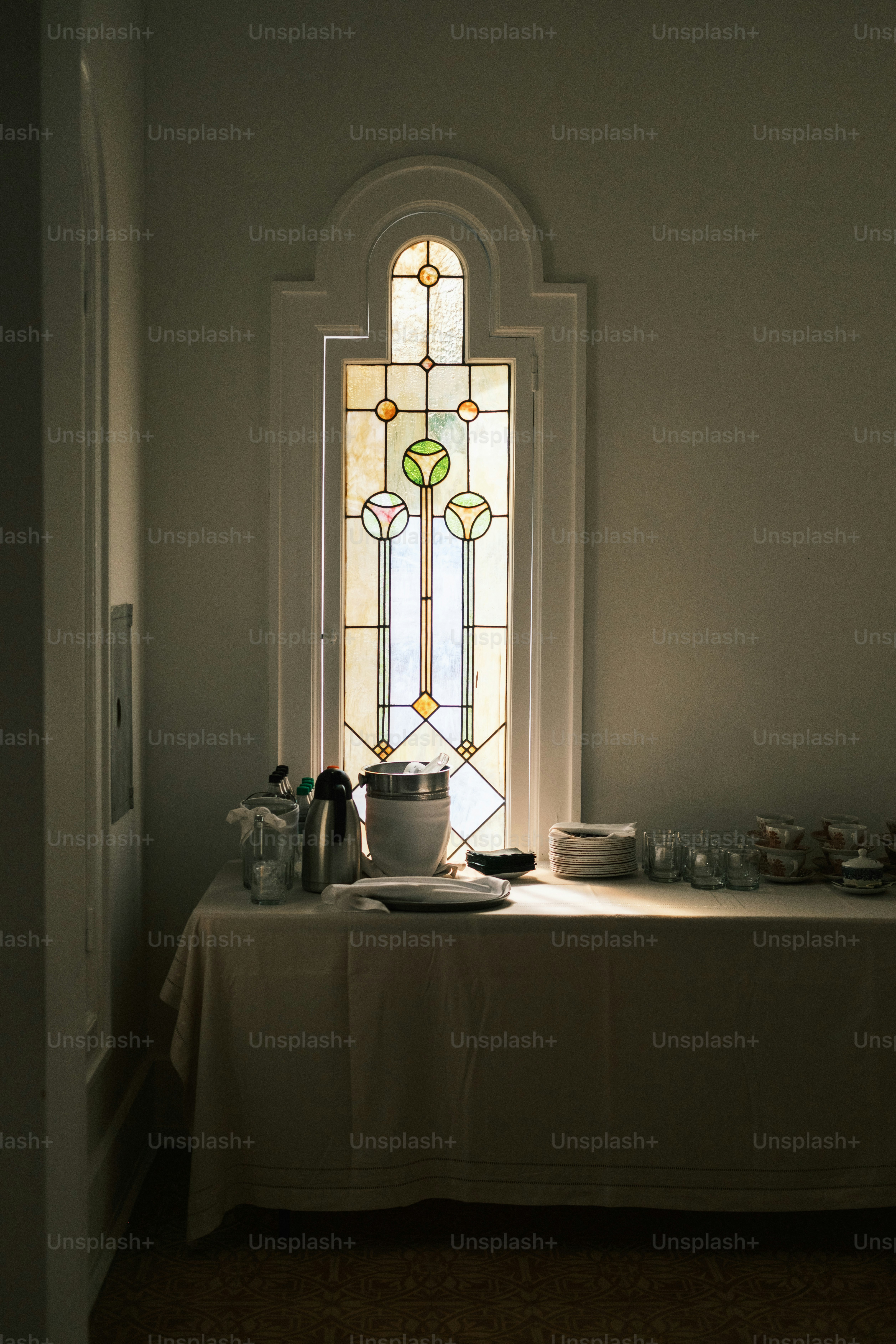Buffettisch steht in der Nähe eines Buntglasfensters.