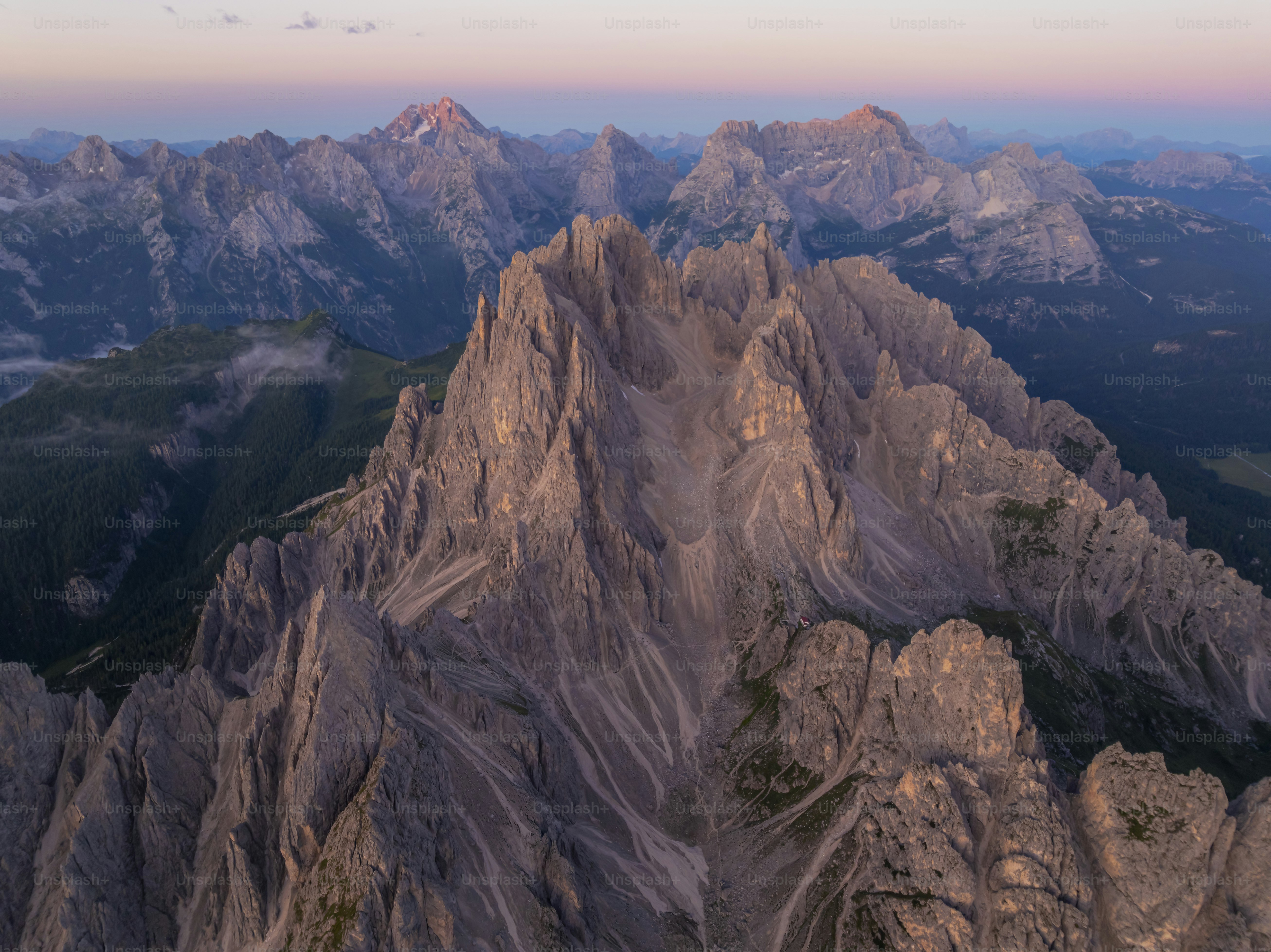 Jagged mountain peaks at sunrise with soft pink sky. photo – Mountains ...