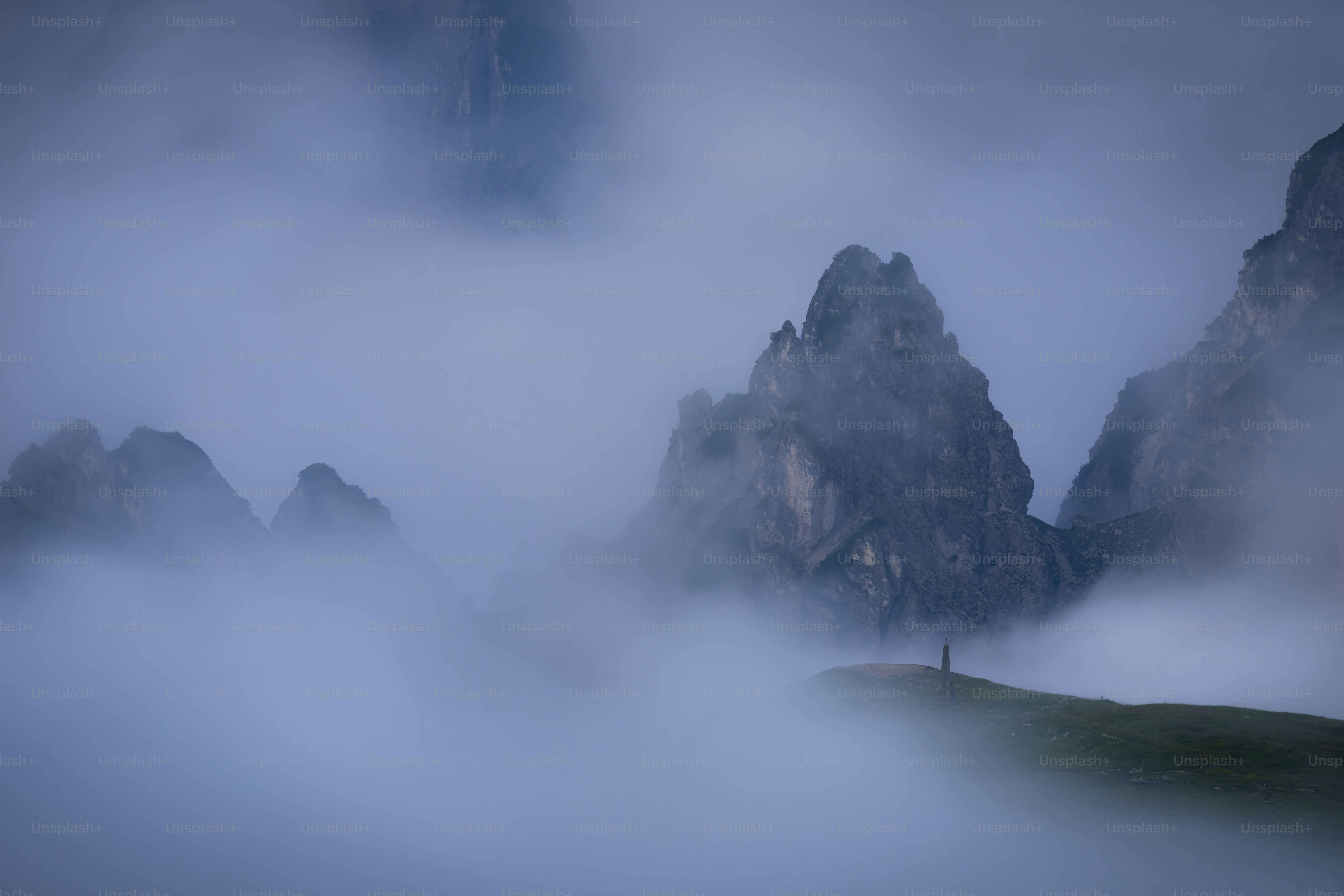 Jagged mountain peaks emerge from thick fog