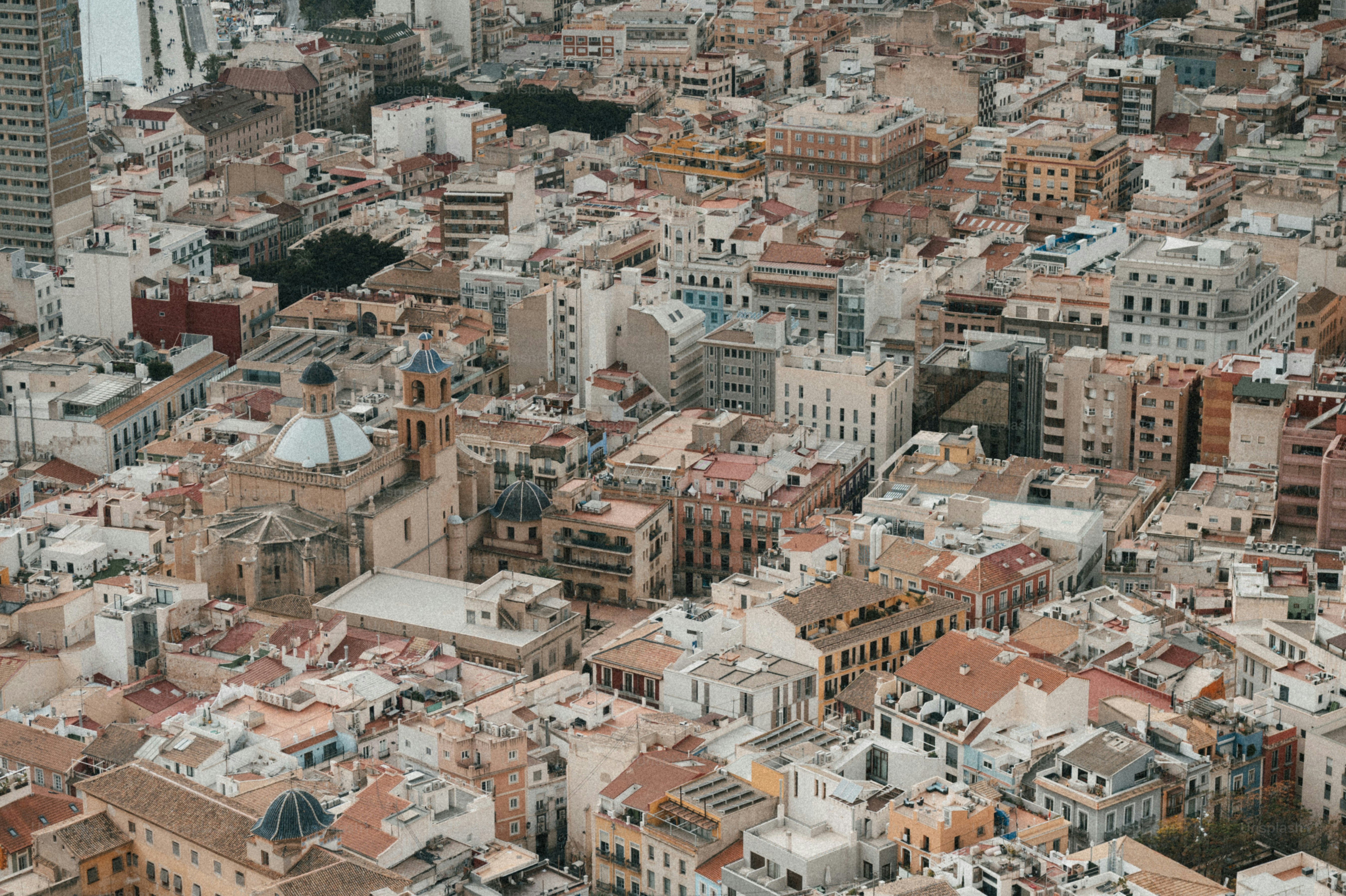 Aerial view of a dense european city with tiled roofs.