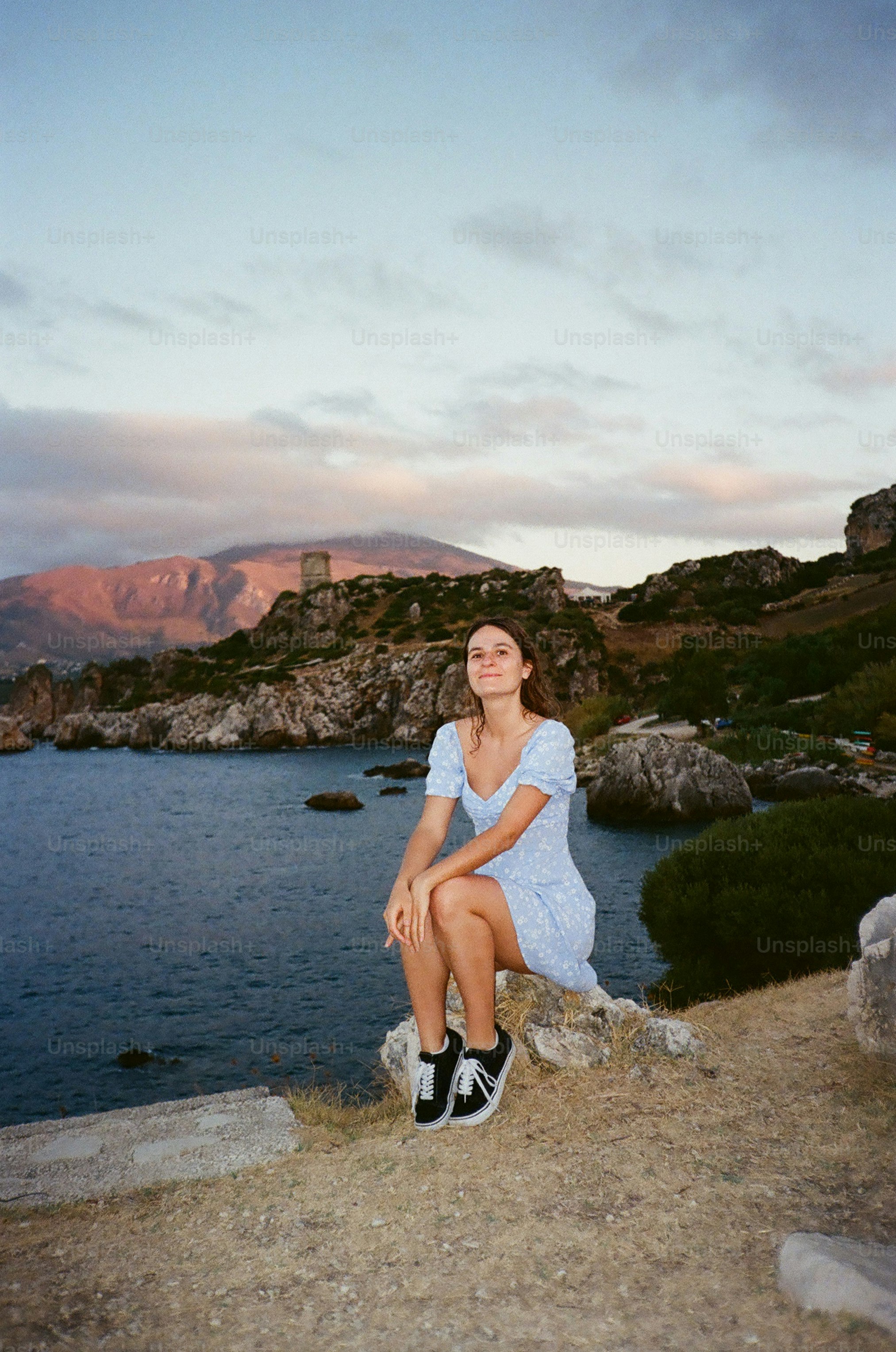 Young woman sitting by the sea at sunset photo – Mountains Image on ...