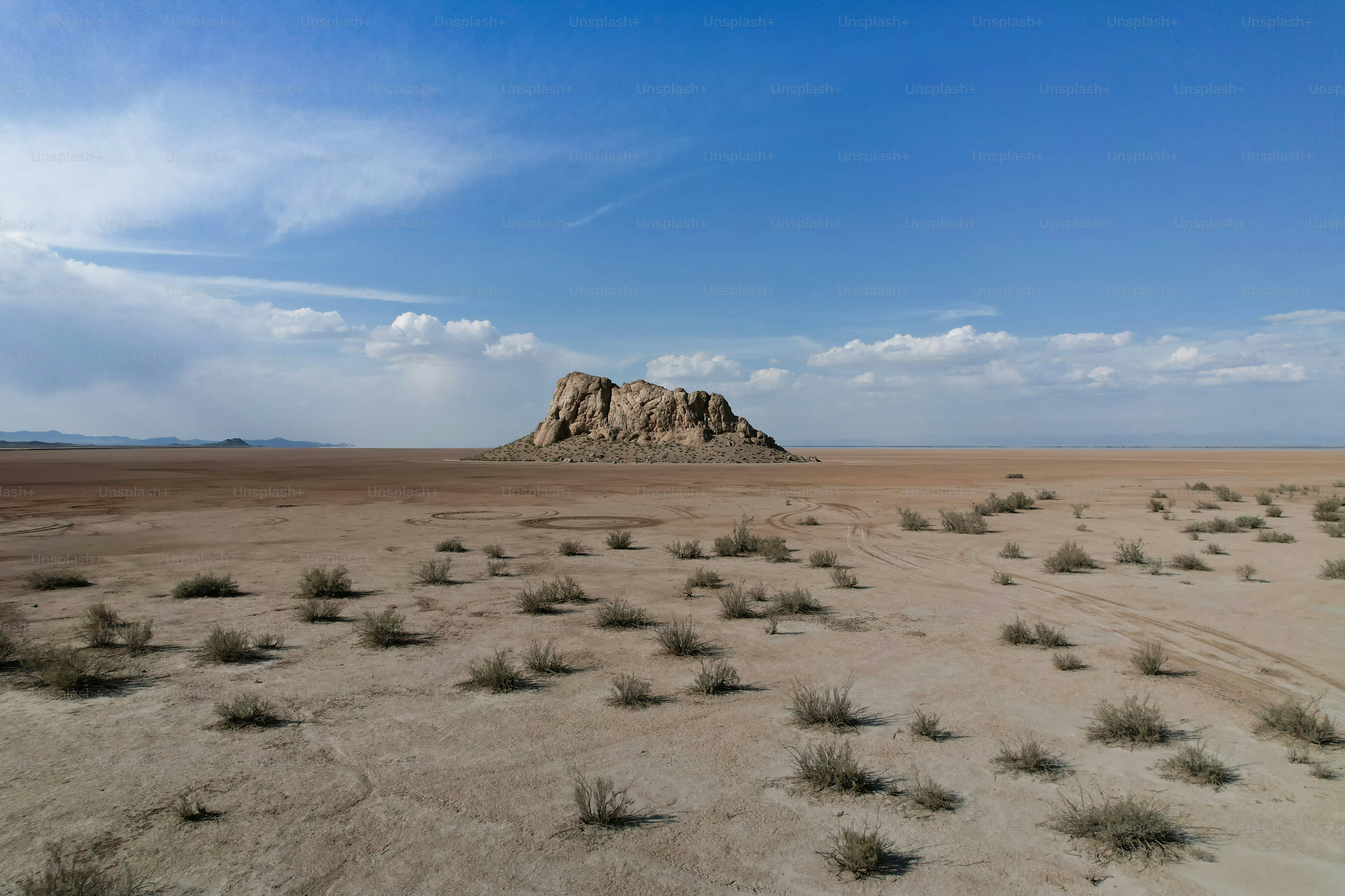 Large rock formation in a barren desert landscape photo – Blue sky ...
