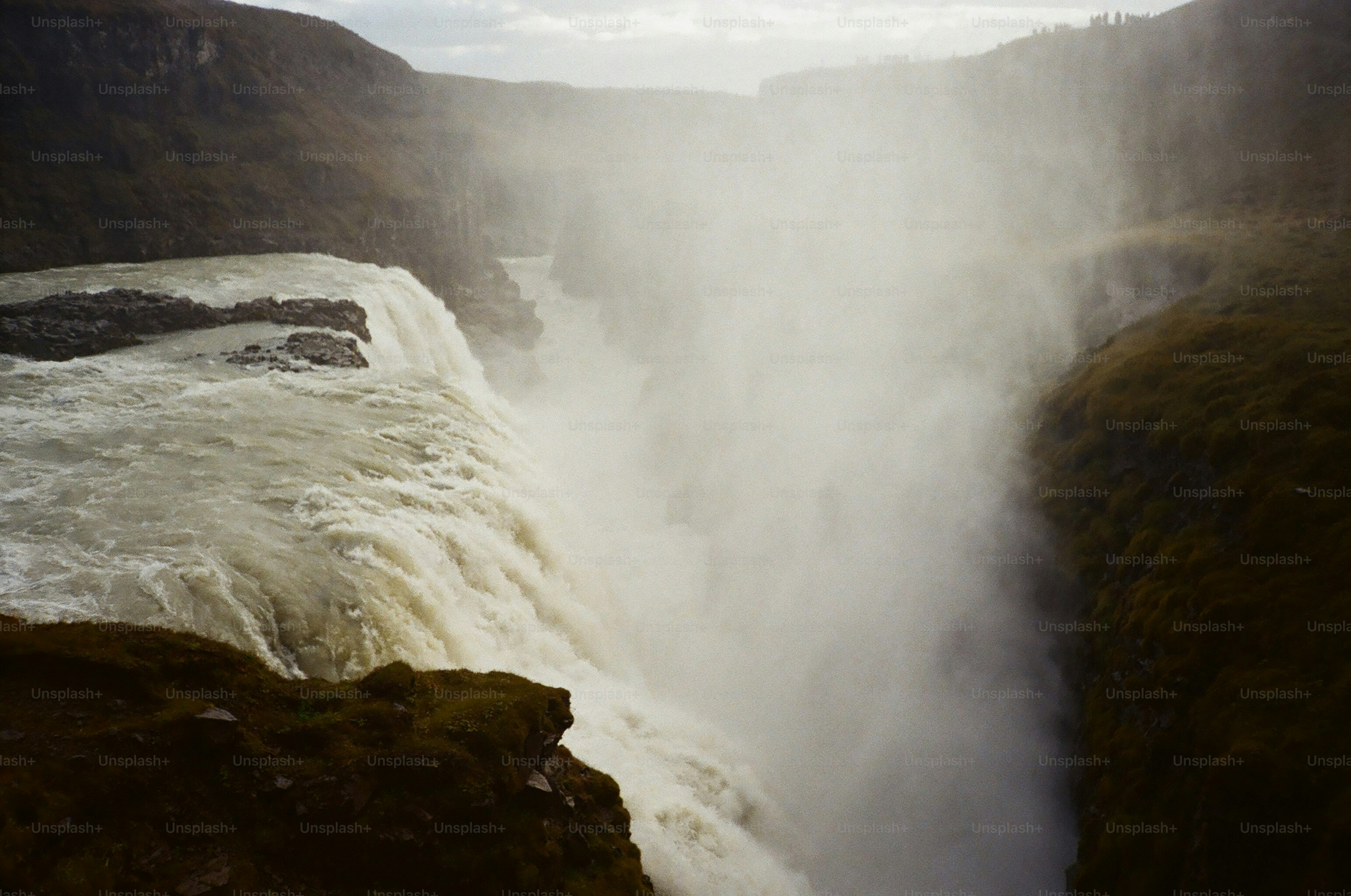 Powerful waterfall cascading into a misty canyon