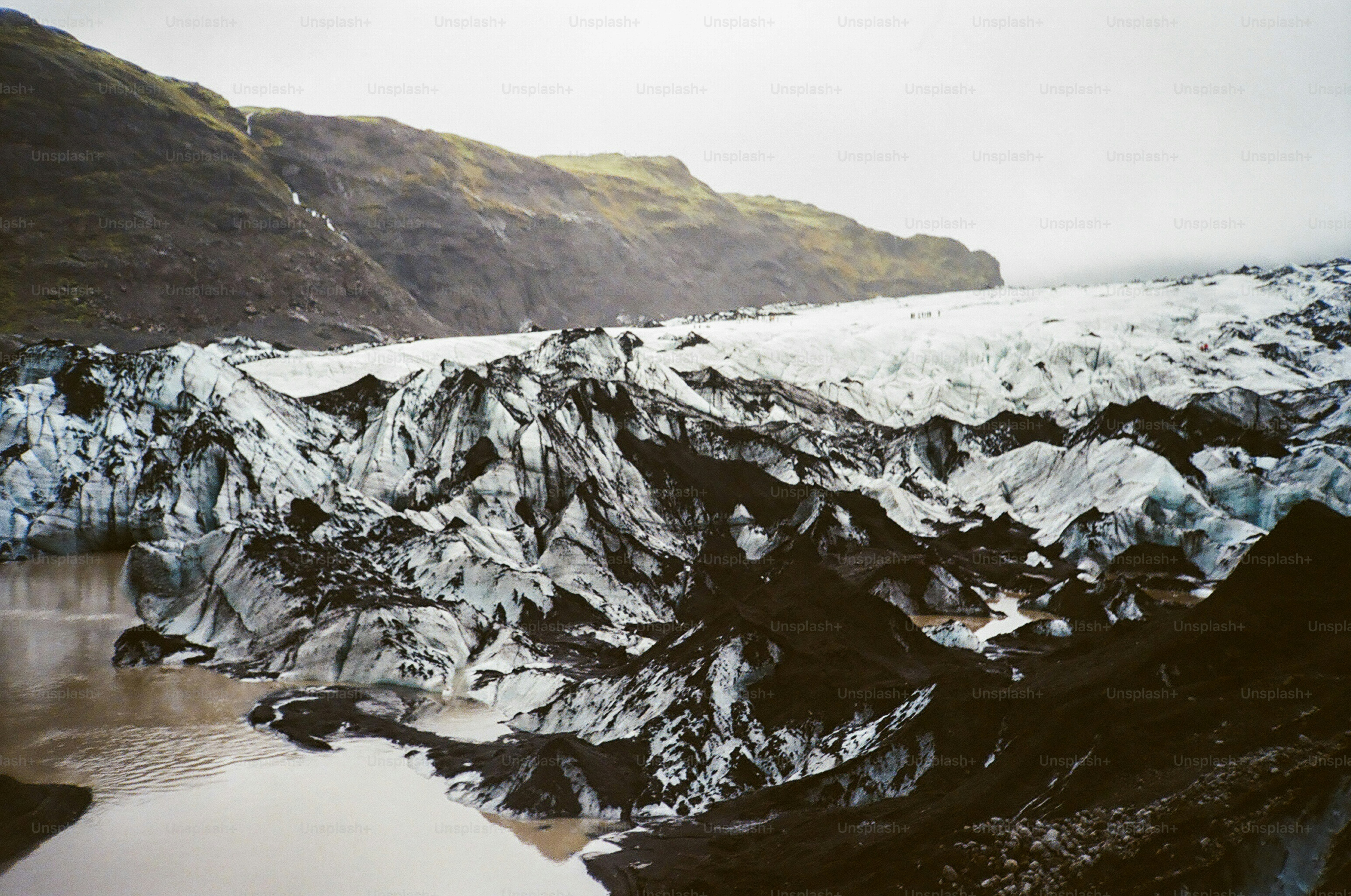 Iceberg with dark ash and muddy water.