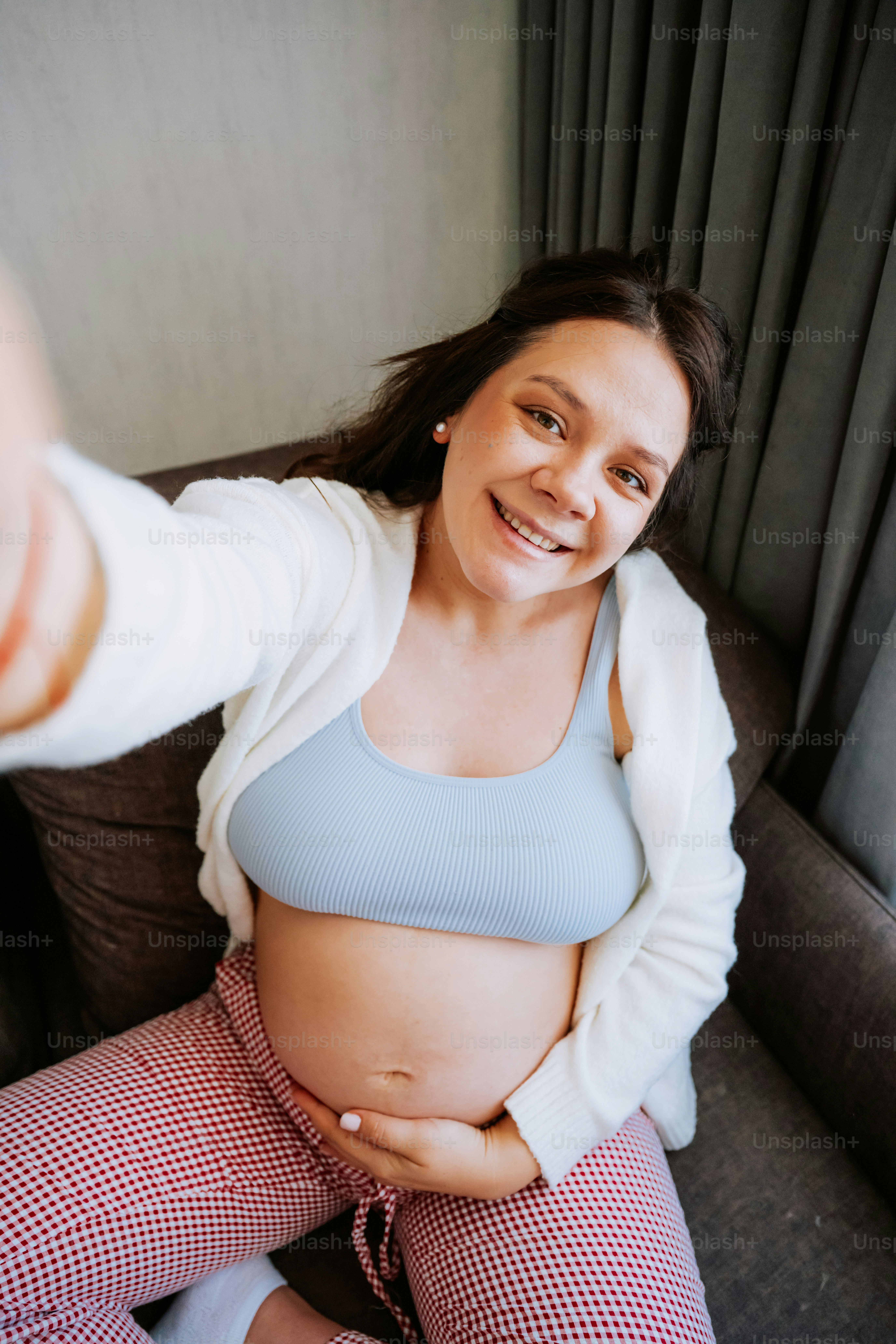 Pregnant woman smiling and holding her belly