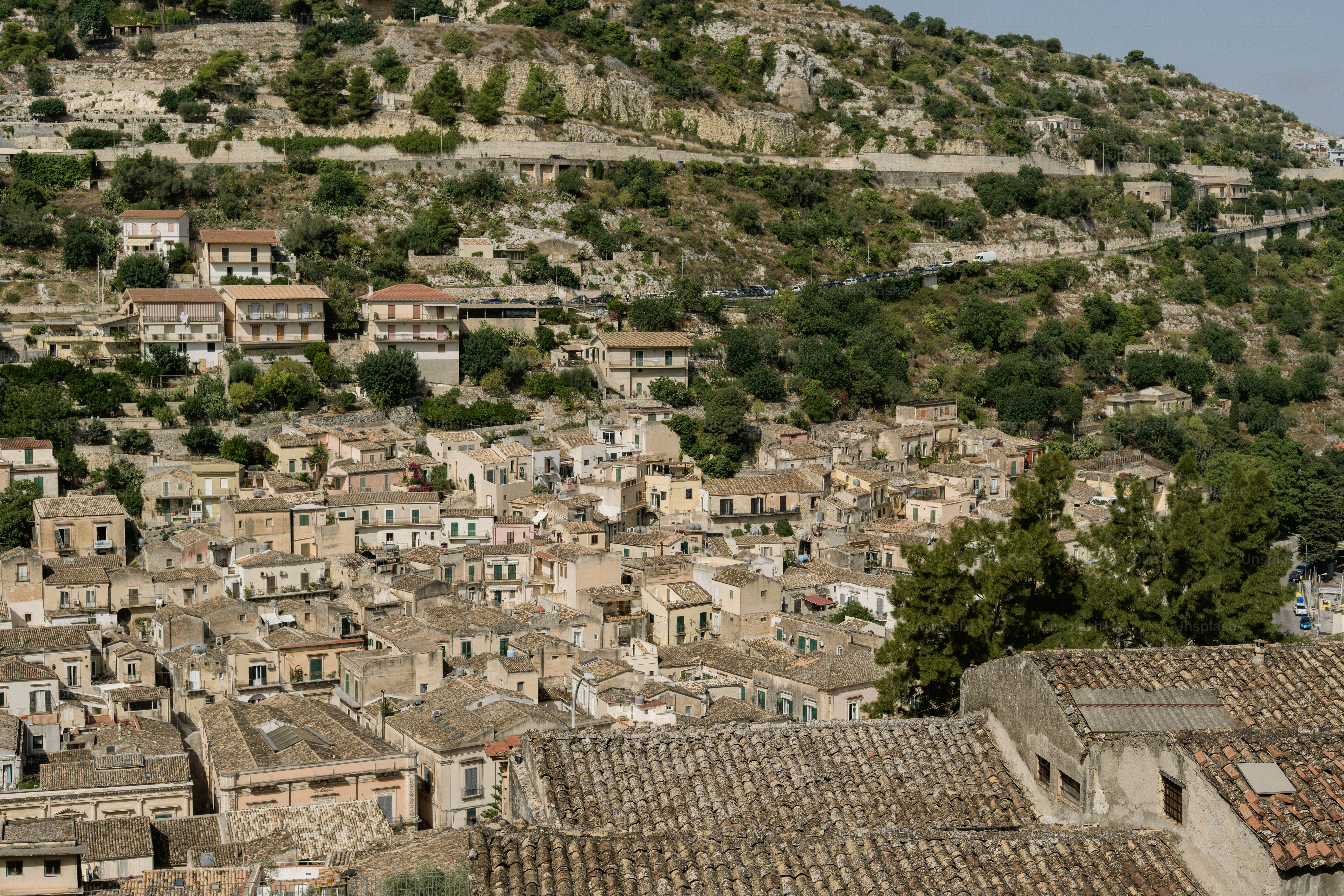 Eine Hügelstadt mit dichten Gebäuden und grünen Bäumen.