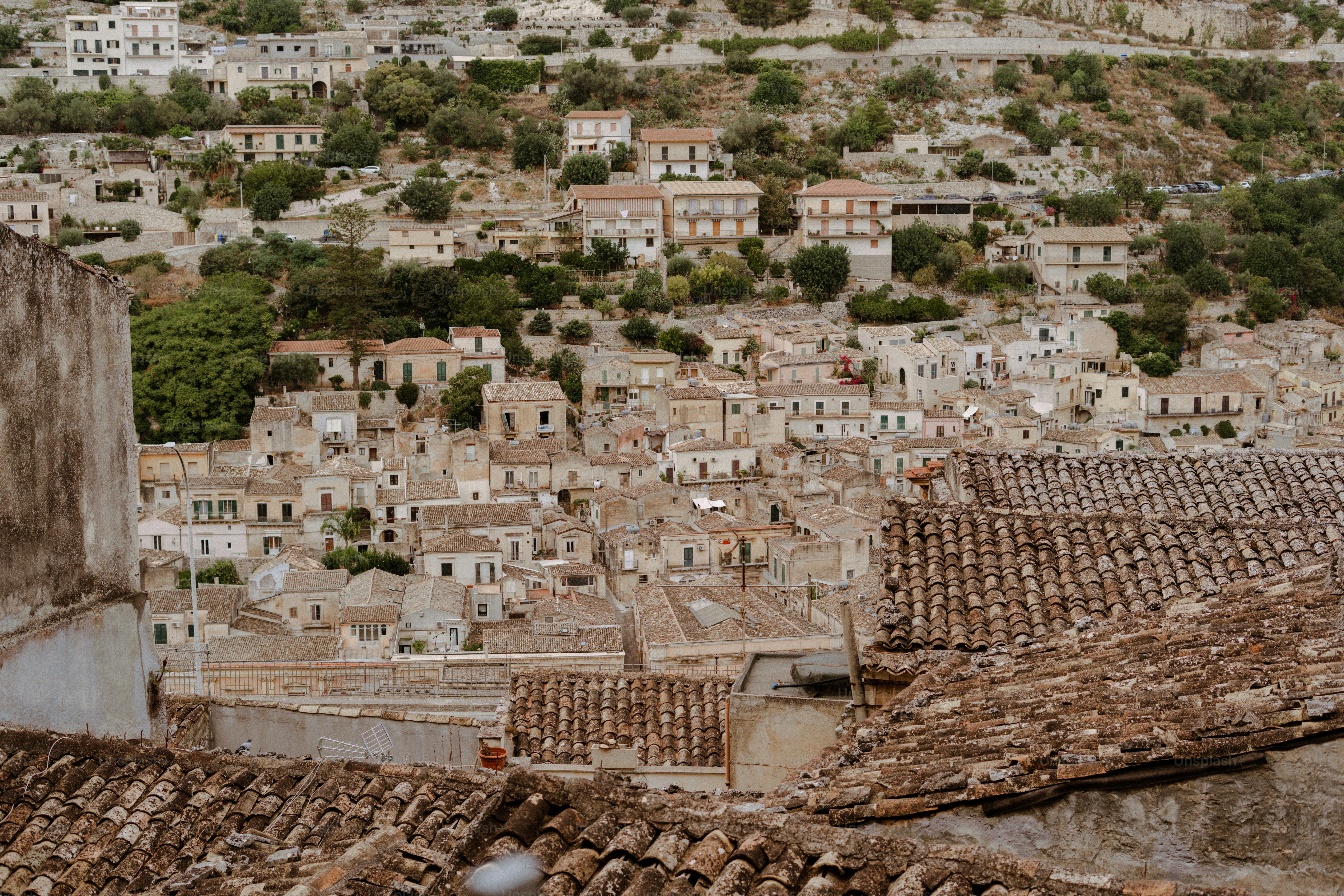Ein Blick auf eine historische Stadt am Hang mit Ziegeldächern.