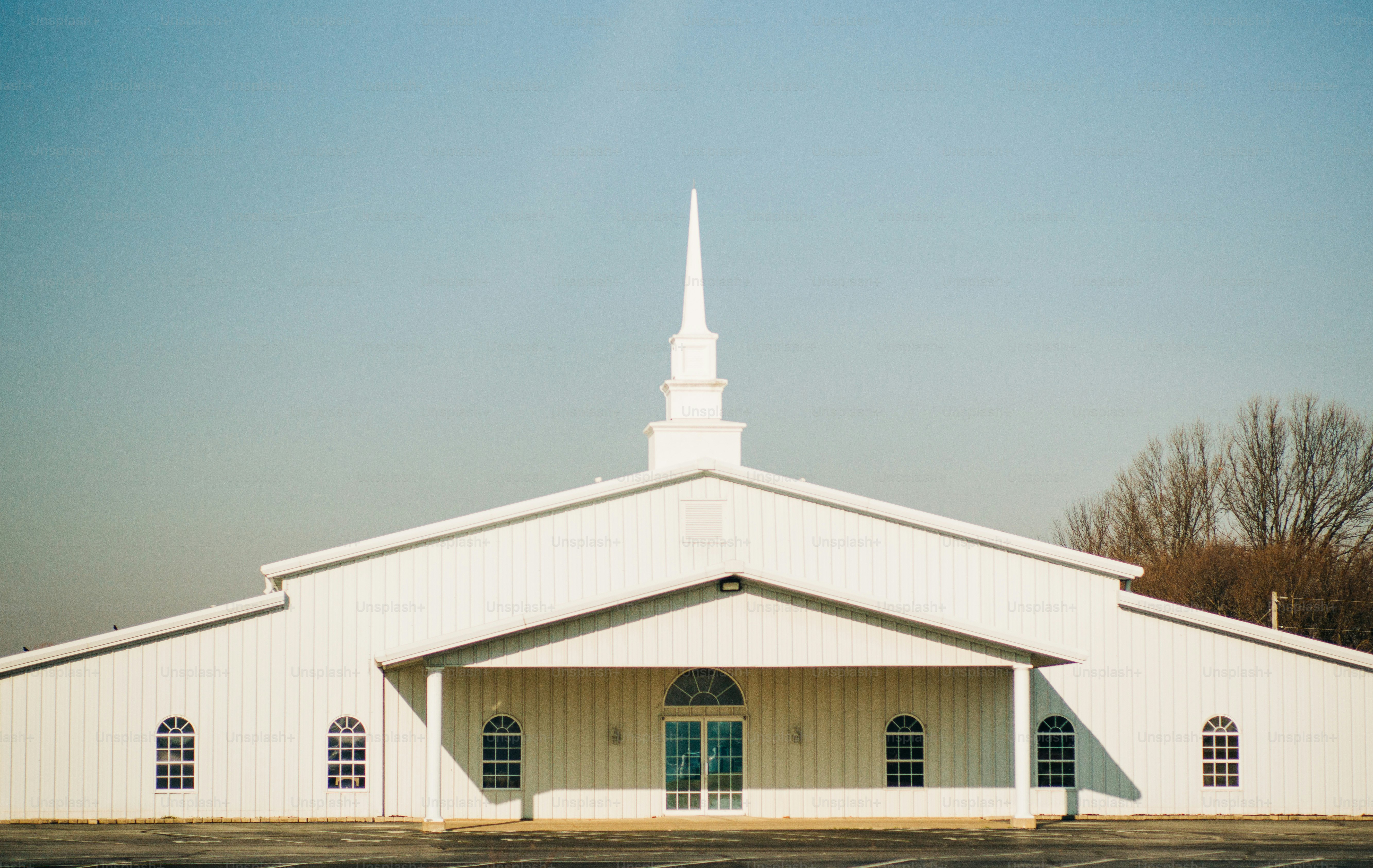 A white church building with a steeple and arched windows