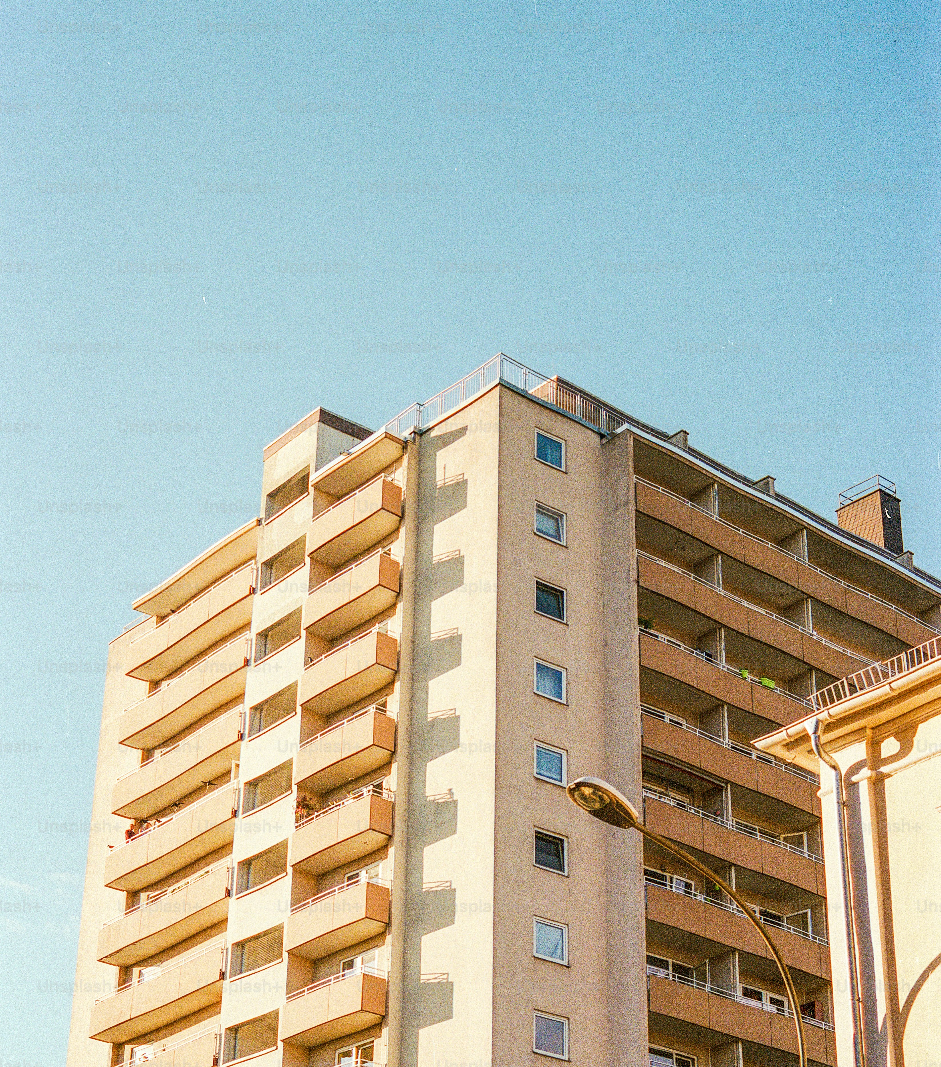 Edificio de apartamentos alto con balcones contra un cielo despejado.