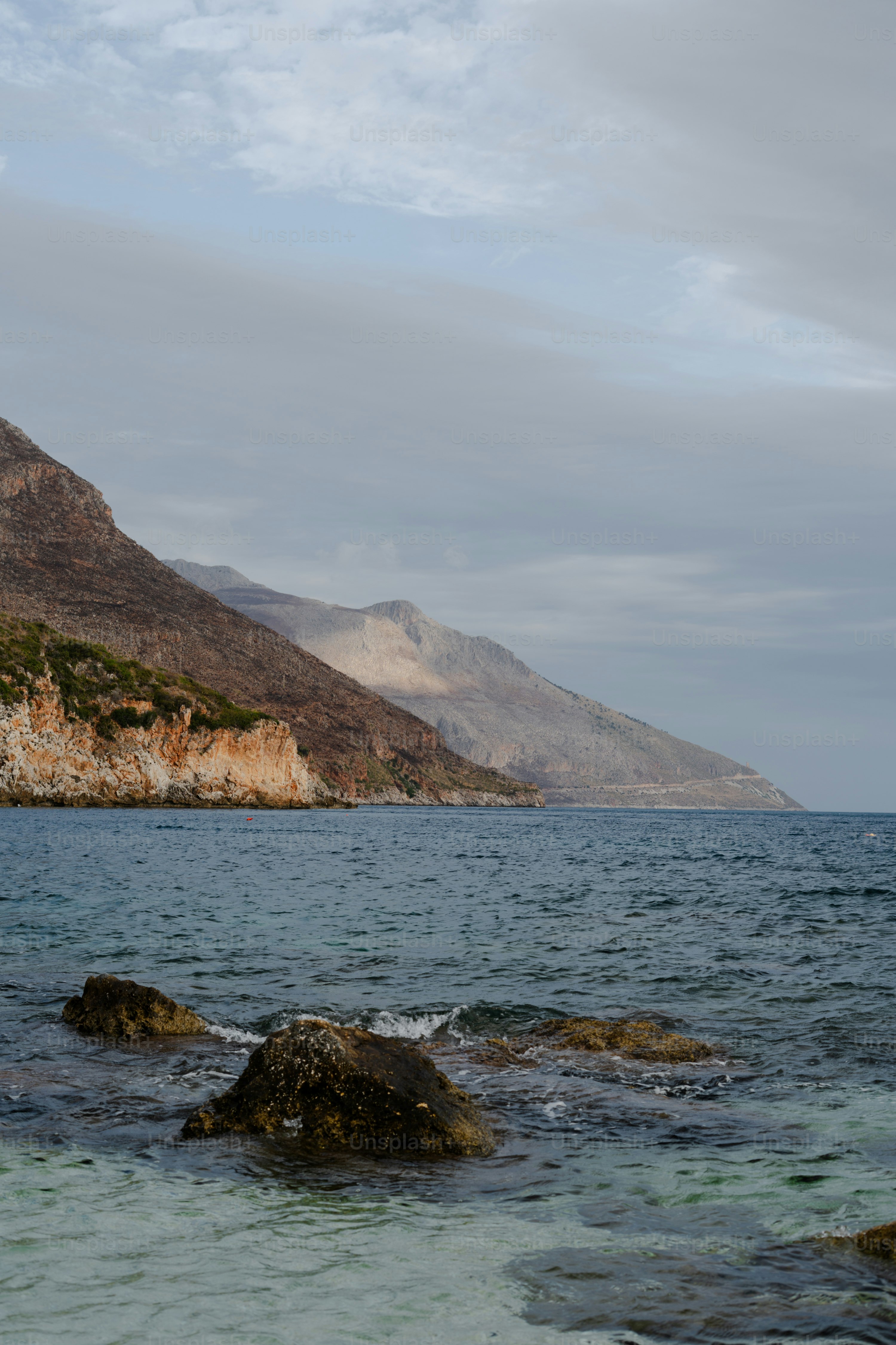 Rocky coastline with calm blue ocean water.
