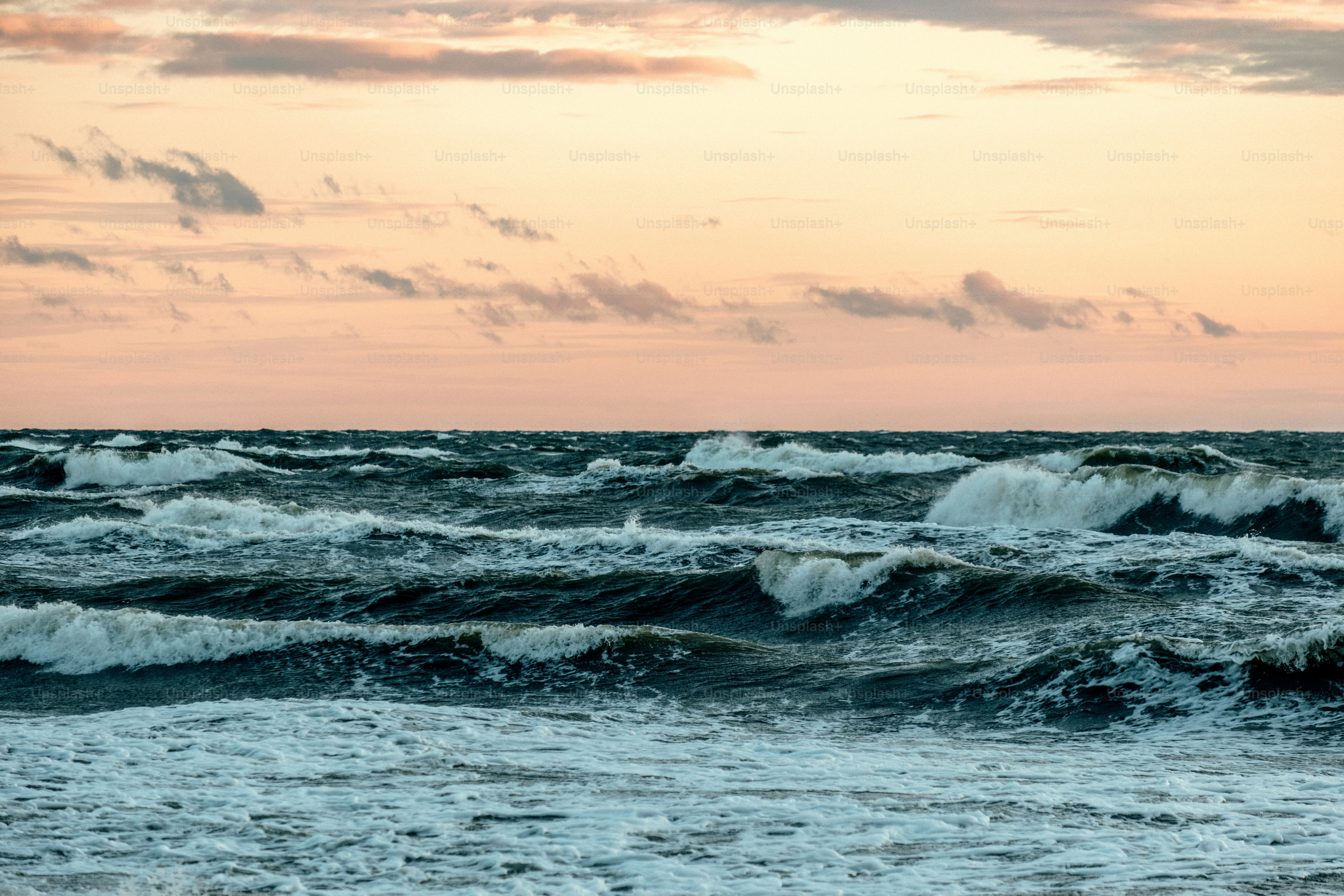 Las olas rompen contra el océano durante una suave puesta de sol.