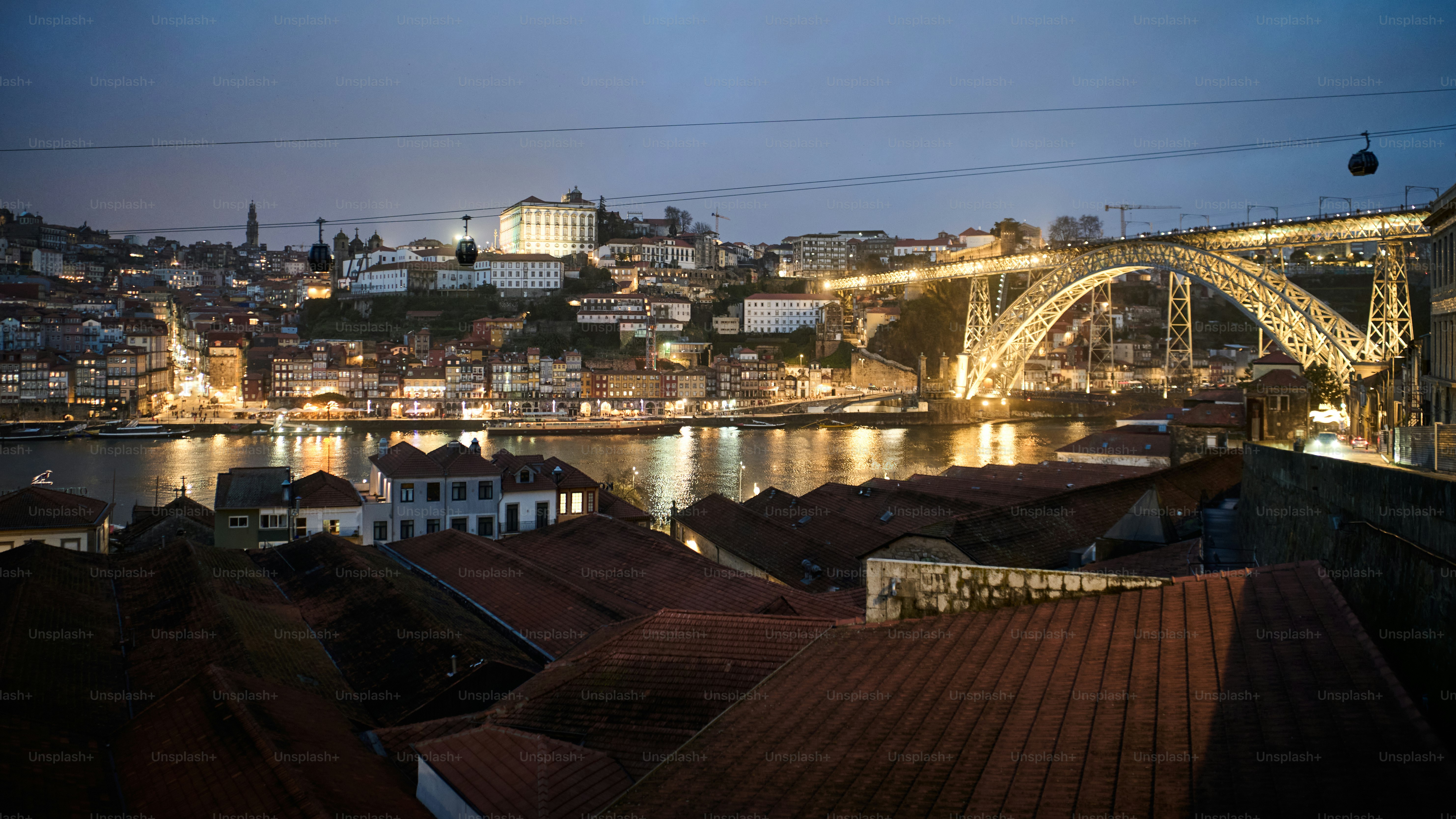 Cityscape with illuminated bridge over river at dusk