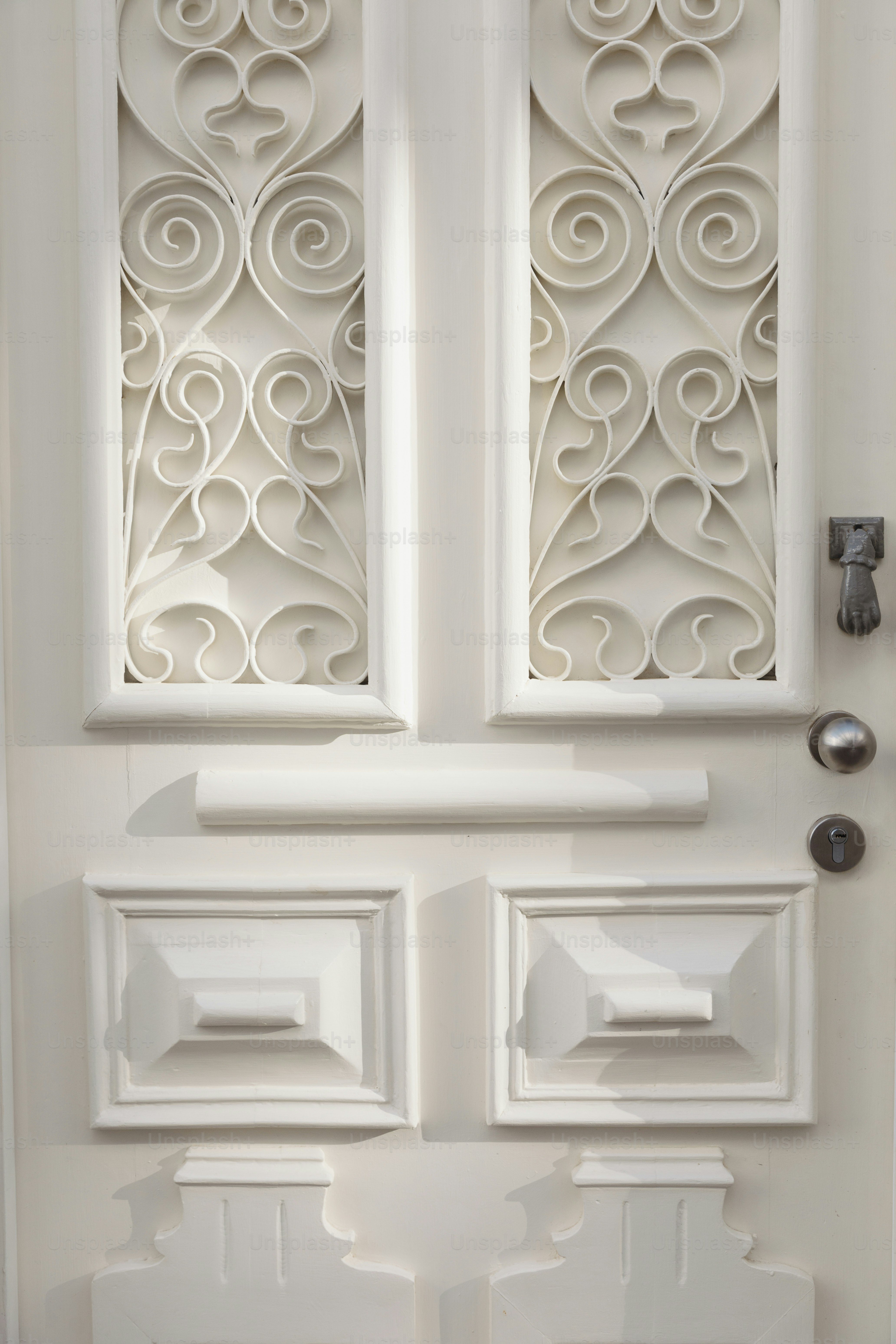 Porta bianca ornata con pannelli decorativi e pannelli geometrici