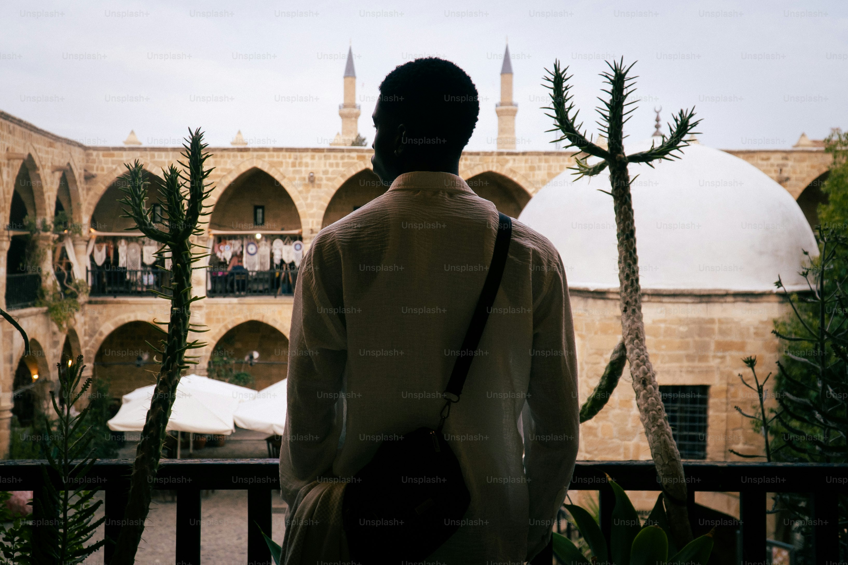 Hombre mirando un edificio histórico con minaretes y cúpula