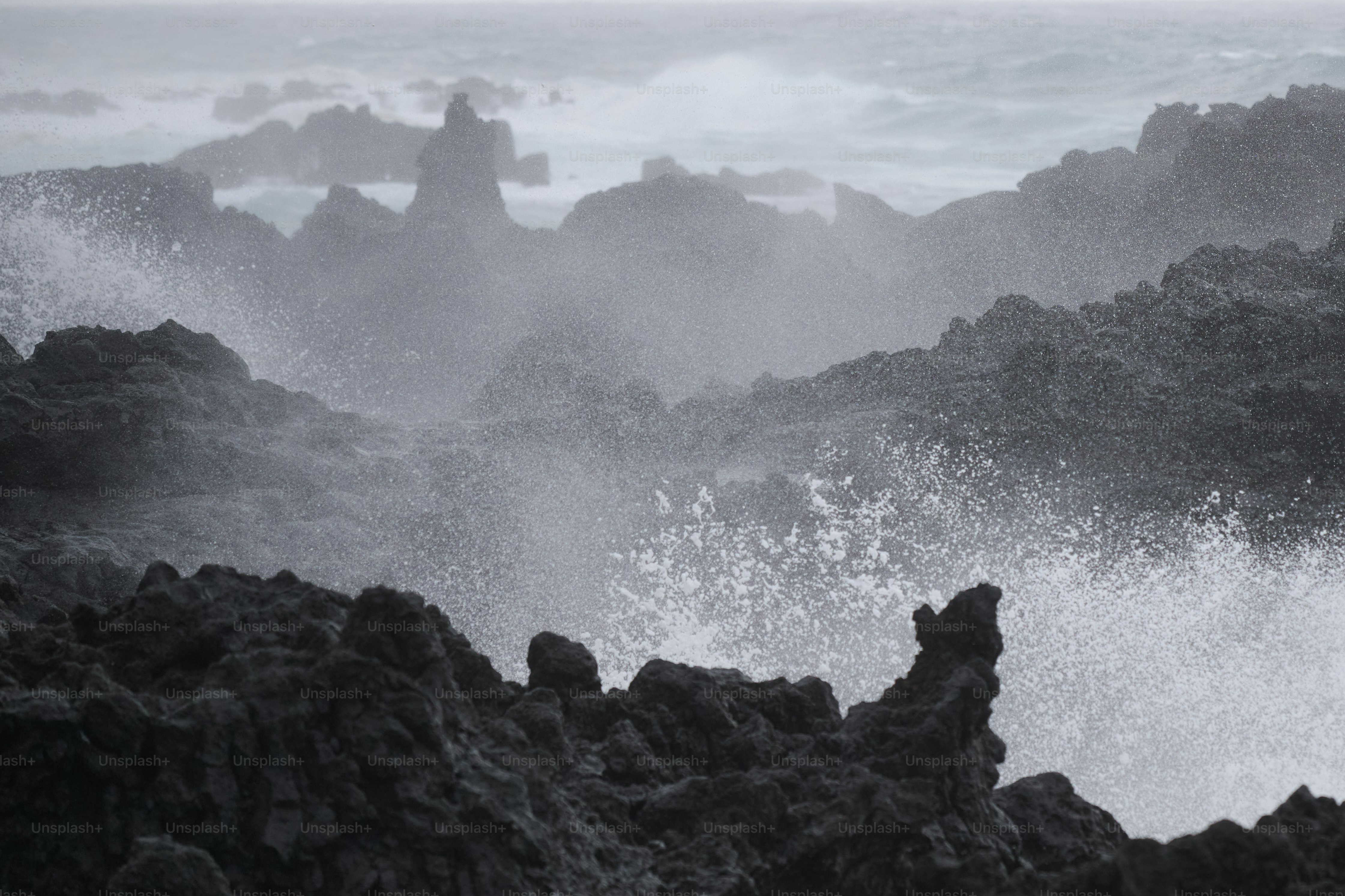 Waves crashing against dark volcanic rocks
