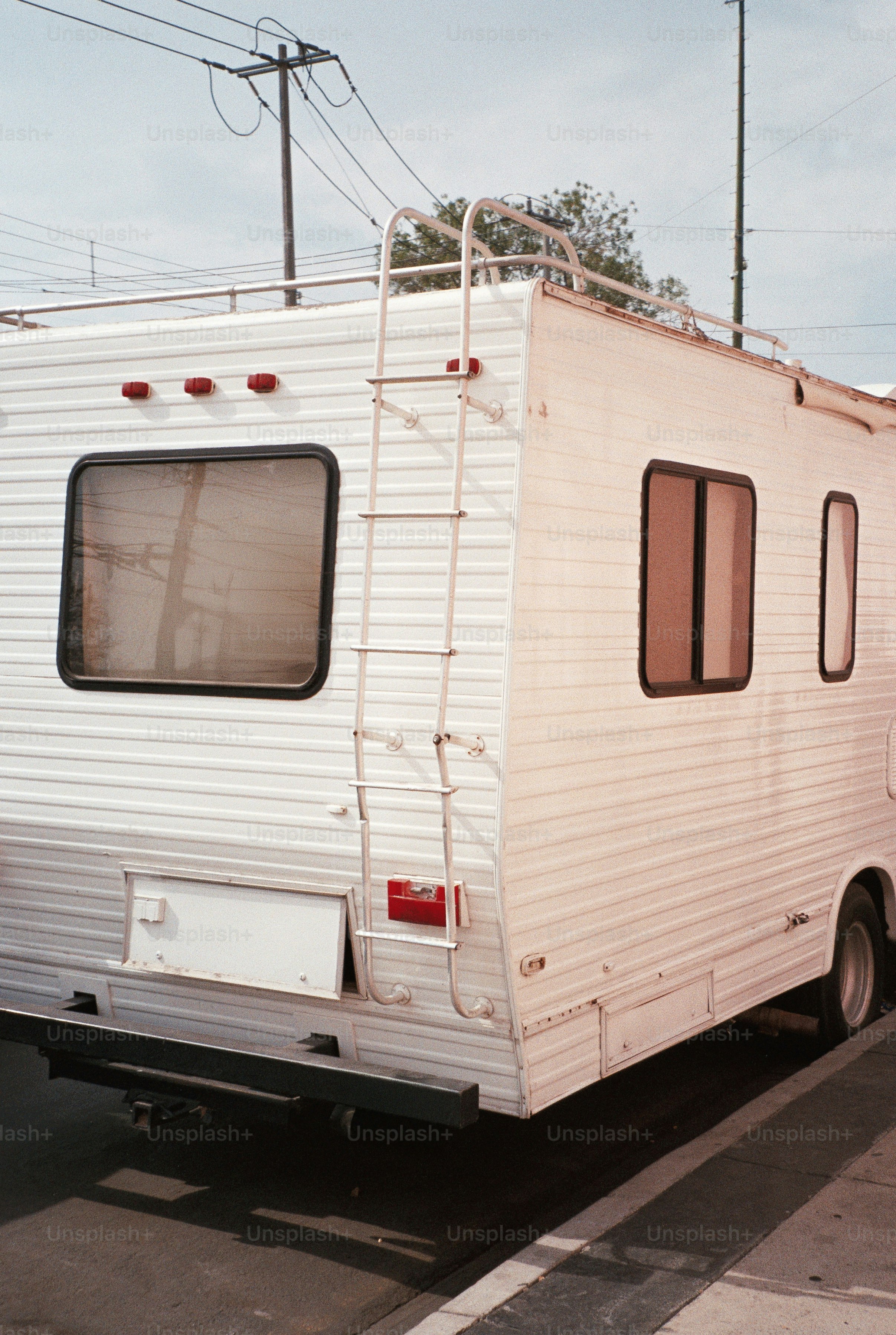 White rv with ladder parked on street