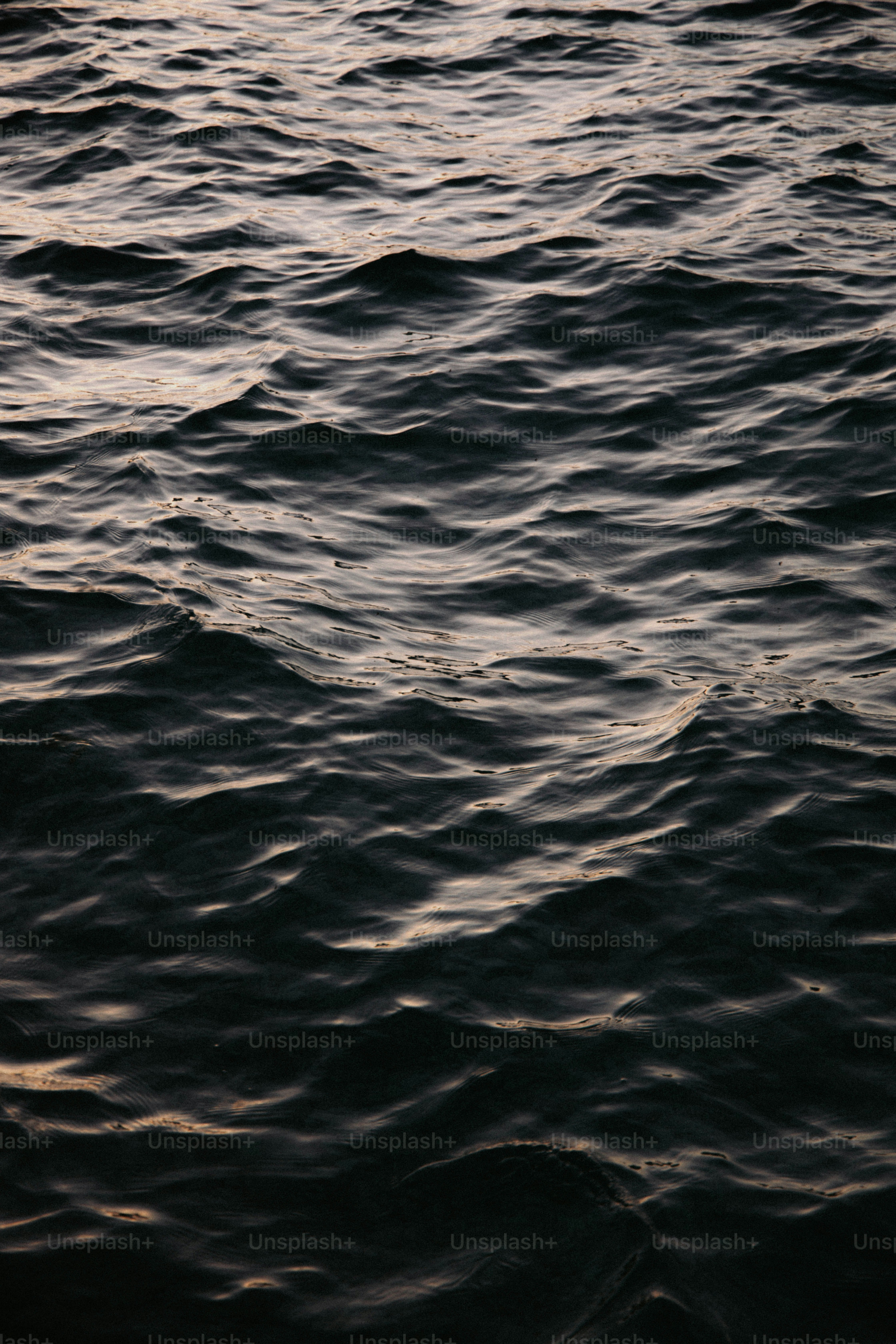 Dark ocean waves at dusk with subtle light reflections