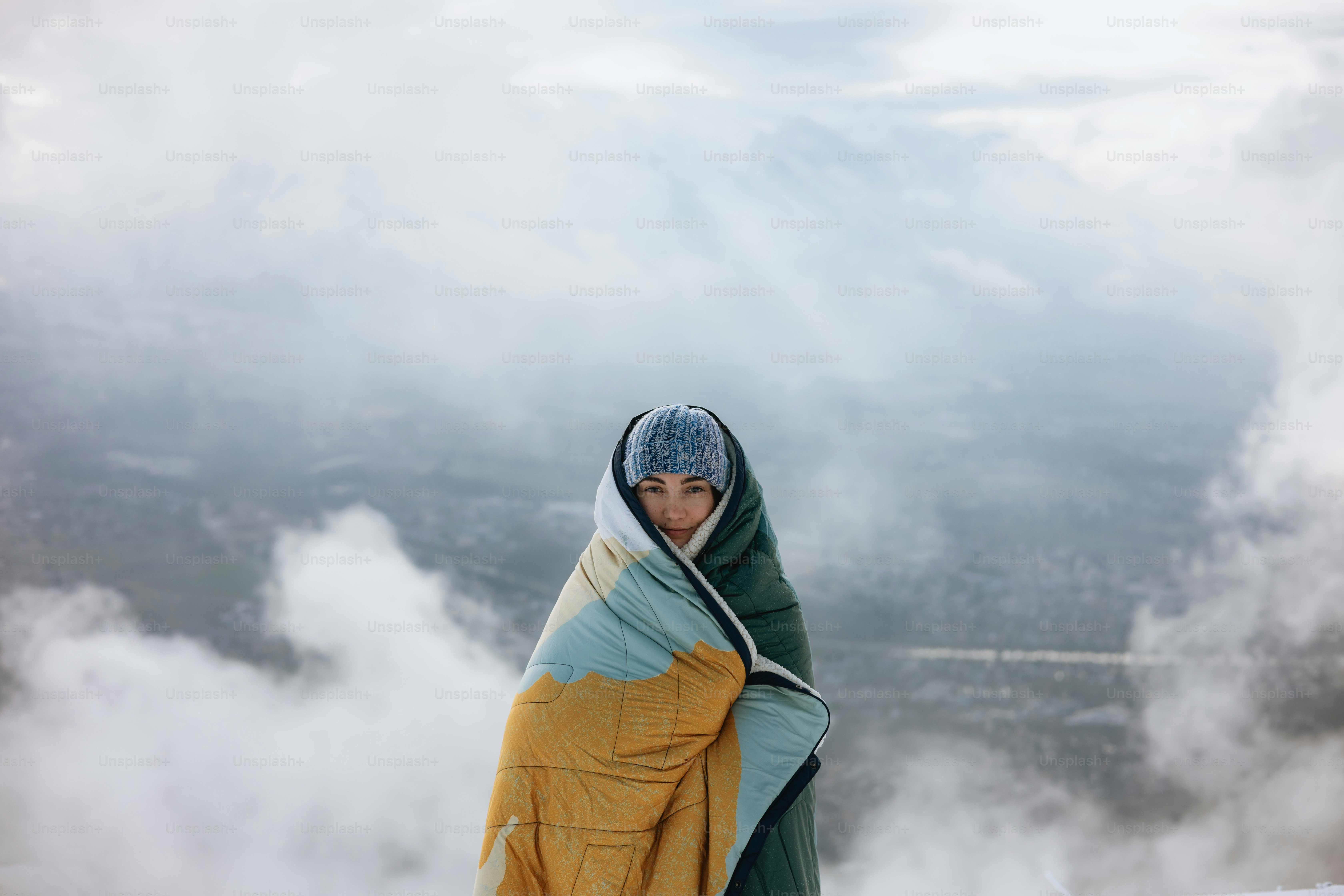 Personne enveloppée dans une couverture au milieu des nuages et du brouillard