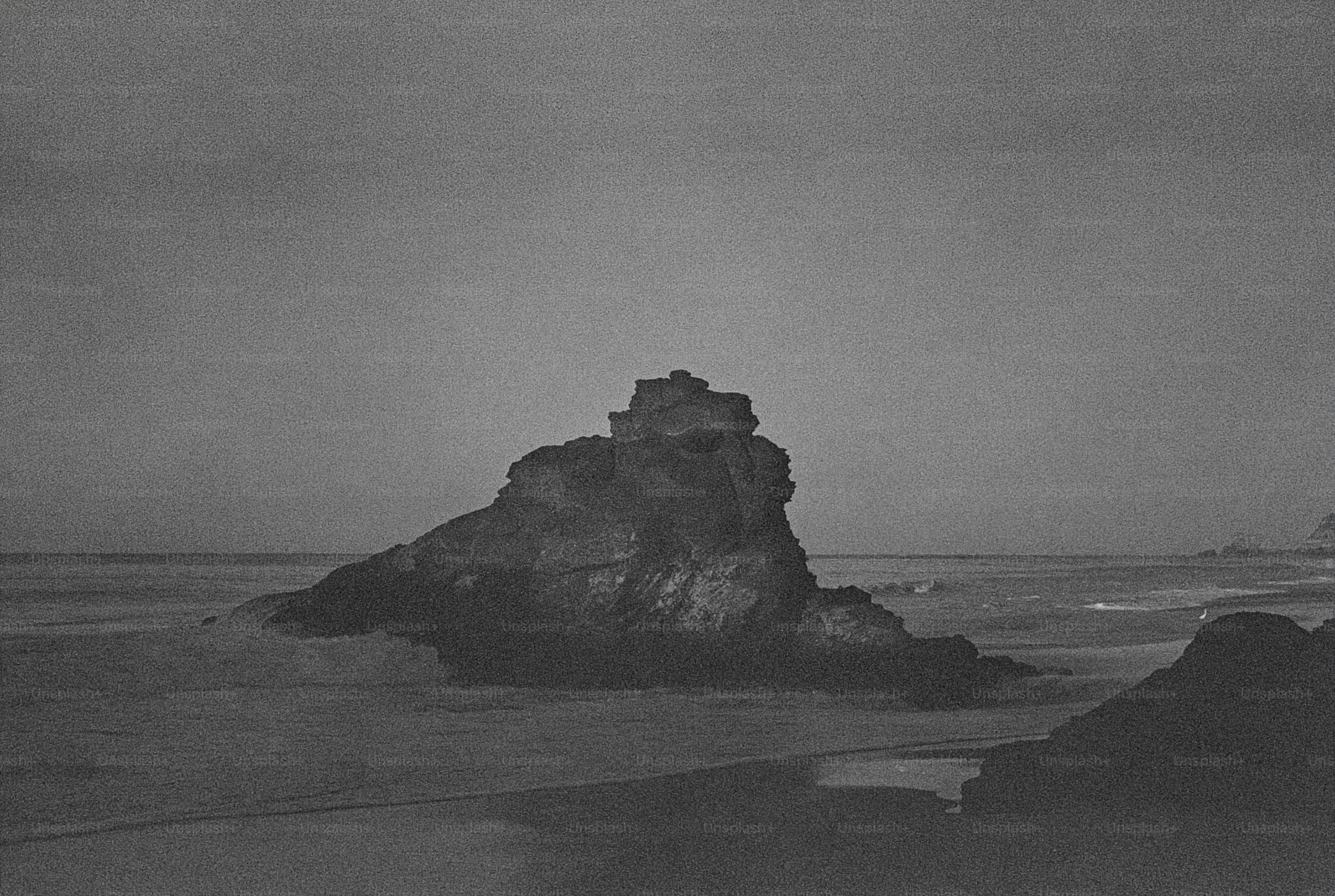 Grande formation rocheuse sur une plage au crépuscule