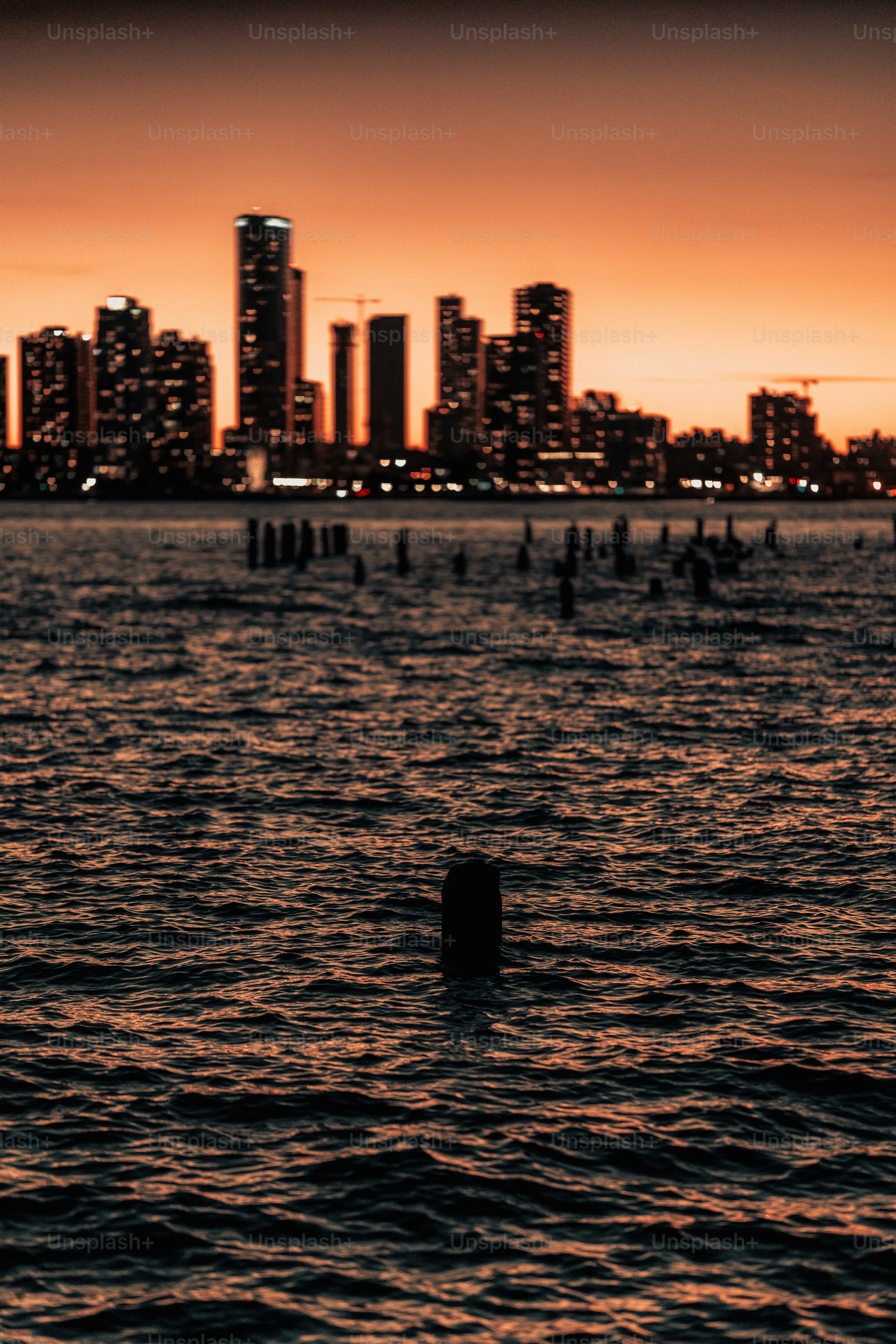 City skyline at sunset over the water.