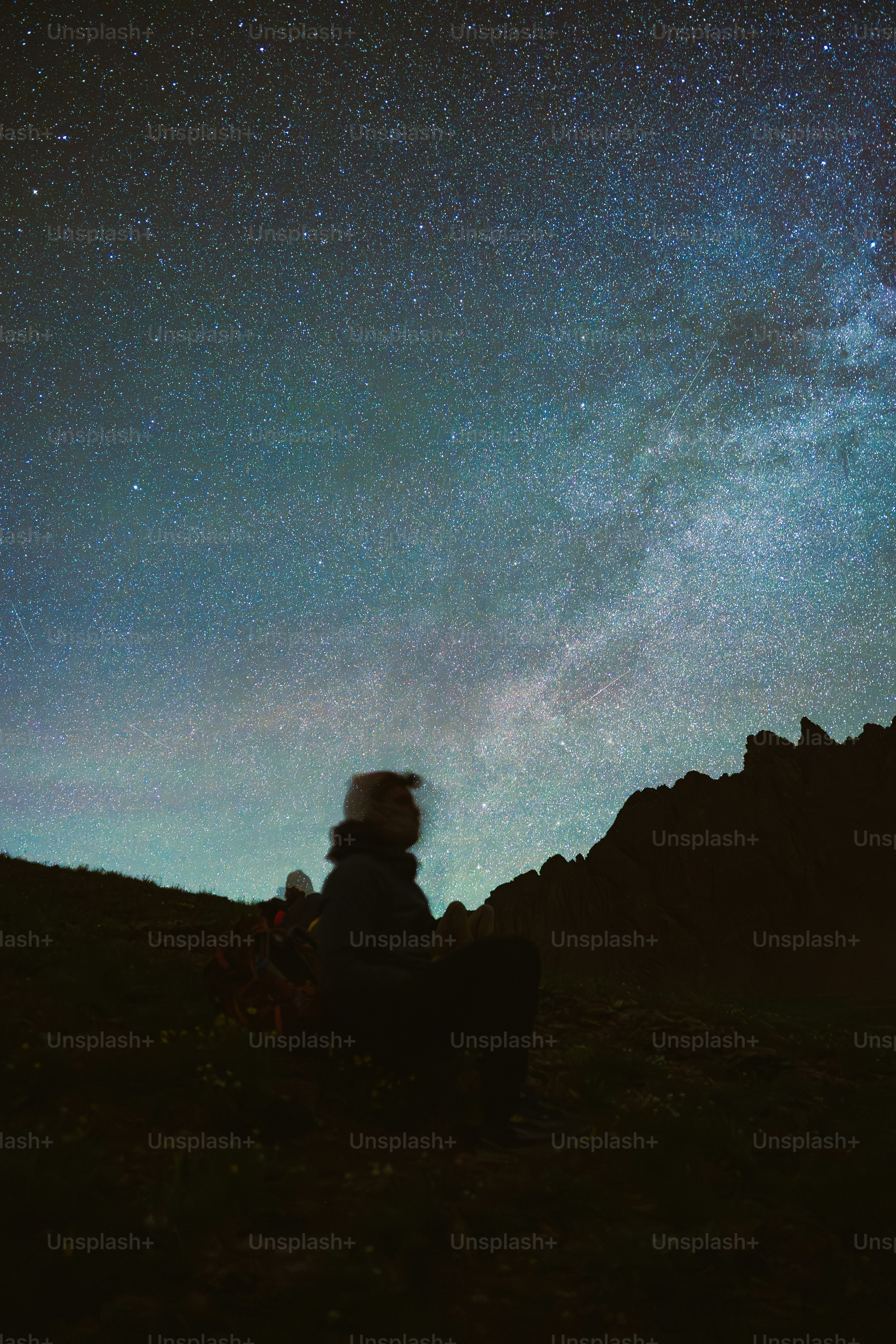 Siluetas de una persona mirando el cielo estrellado.