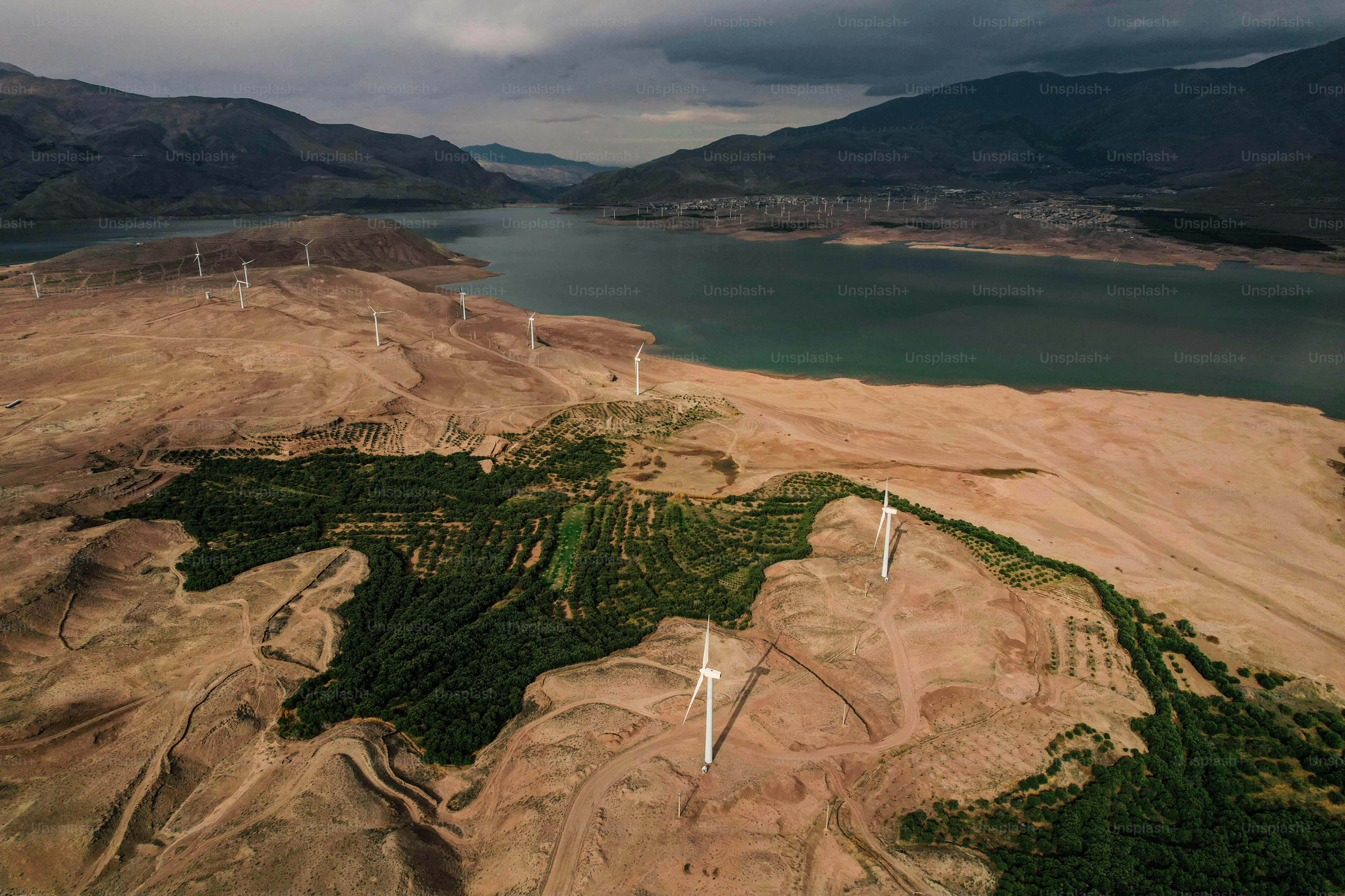 Turbinas eólicas em uma paisagem seca próxima a um lago