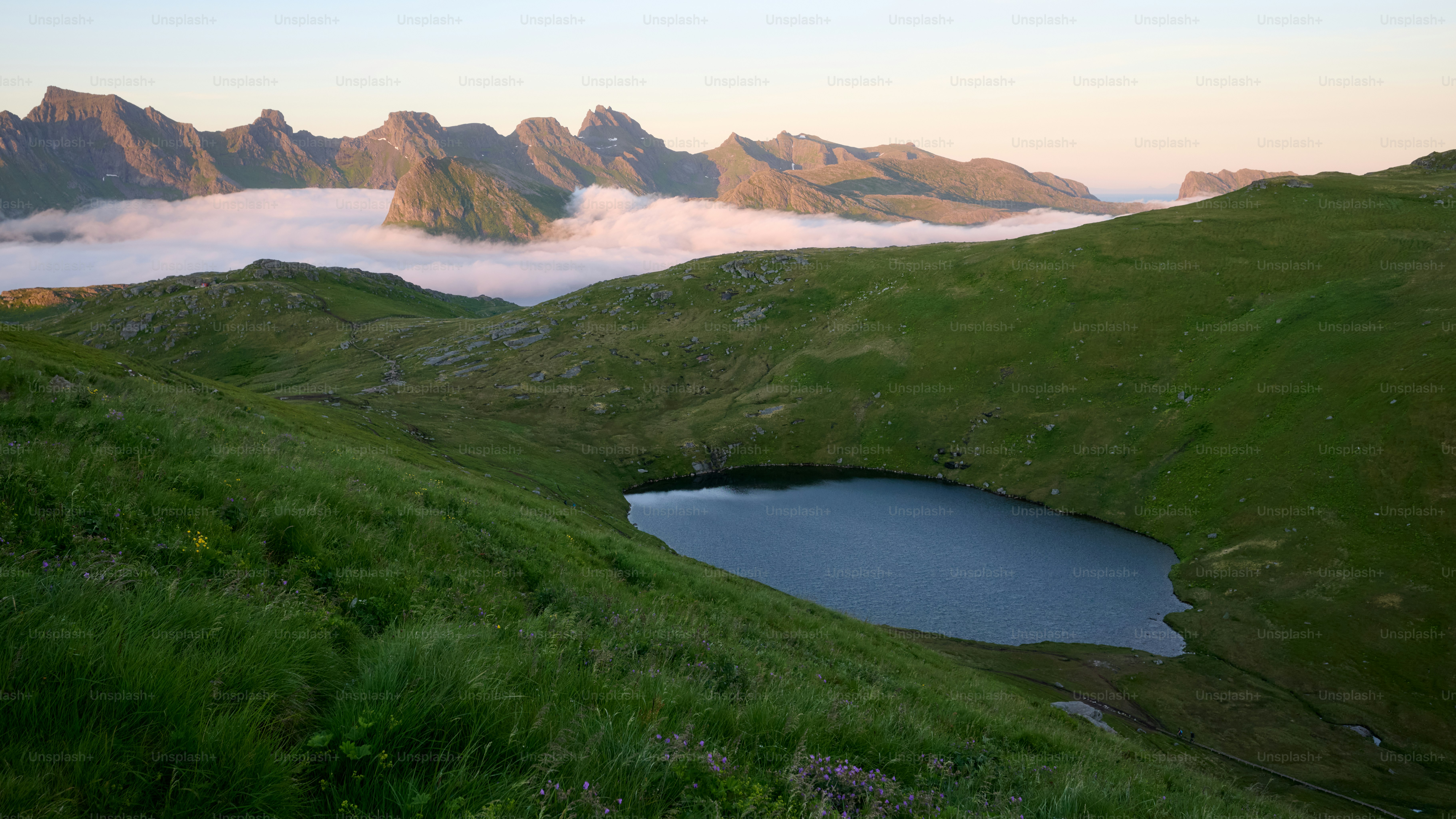 Kleiner See, umgeben von grünen Hügeln und Bergen