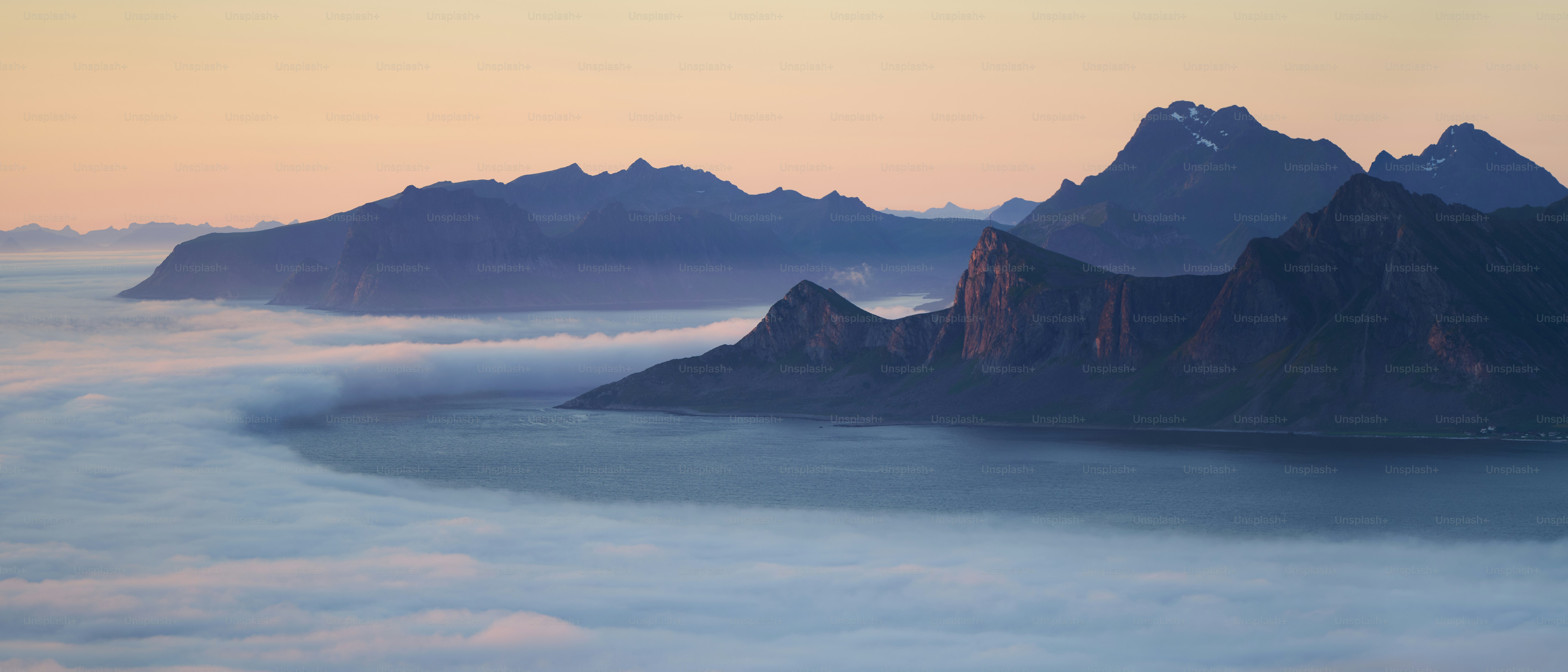 Majestätische Berggipfel ragen aus einem Meer aus Wolken empor.