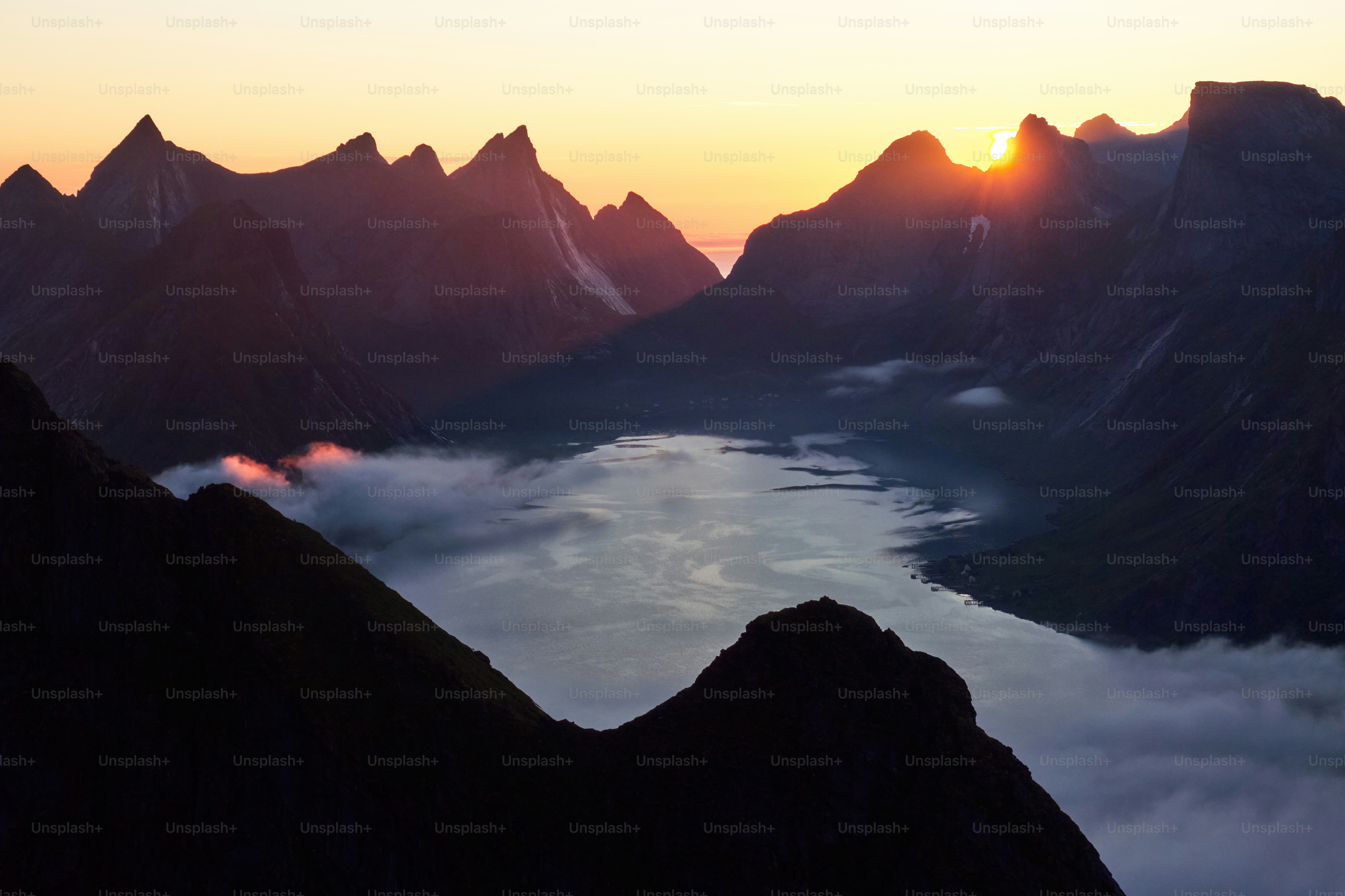 Sonnenaufgang über einem nebligen Bergtal