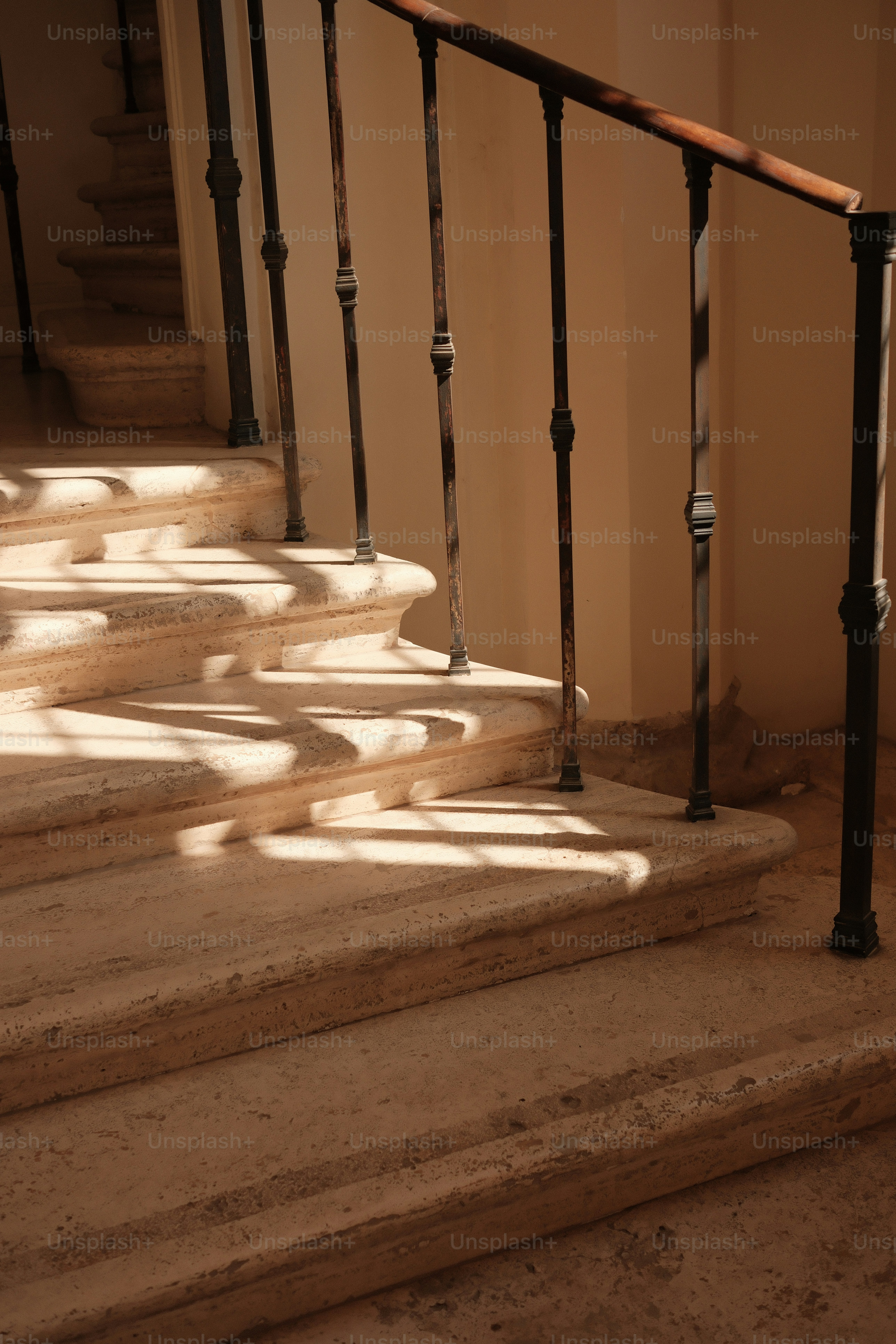 Sunlit staircase with ornate metal railing