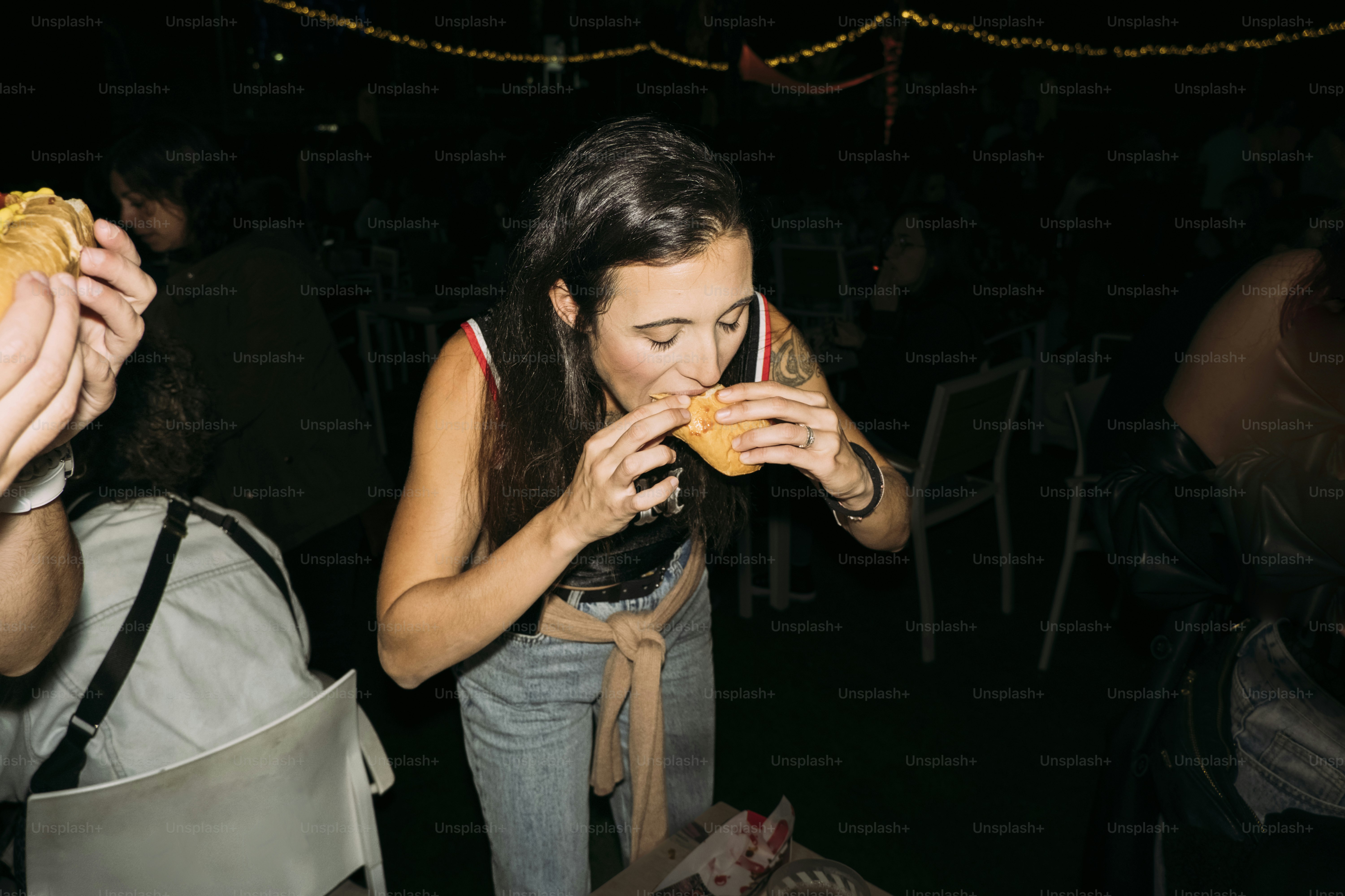 Donna che mangia un hamburger a una festa