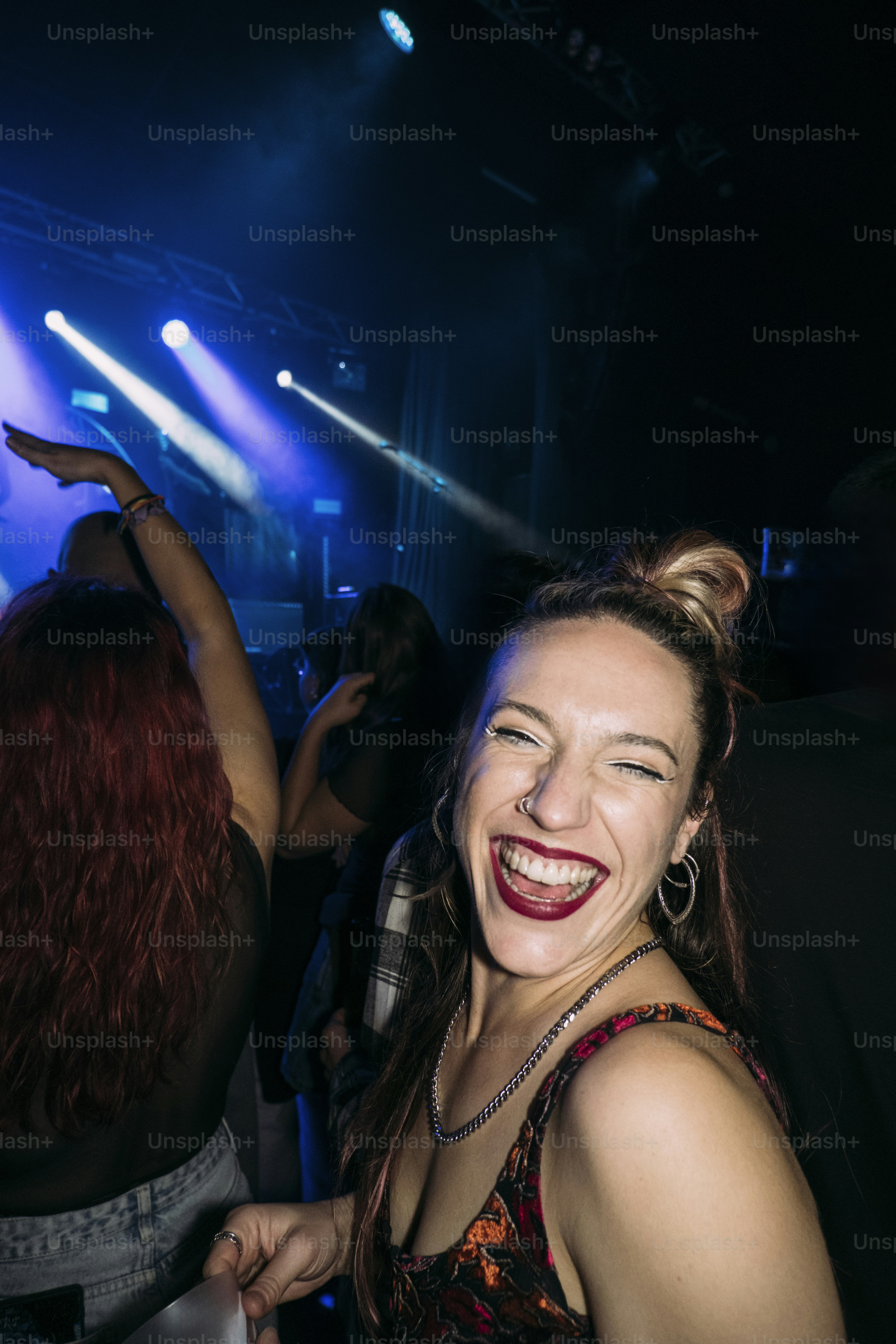Woman laughing at a concert with blue lights