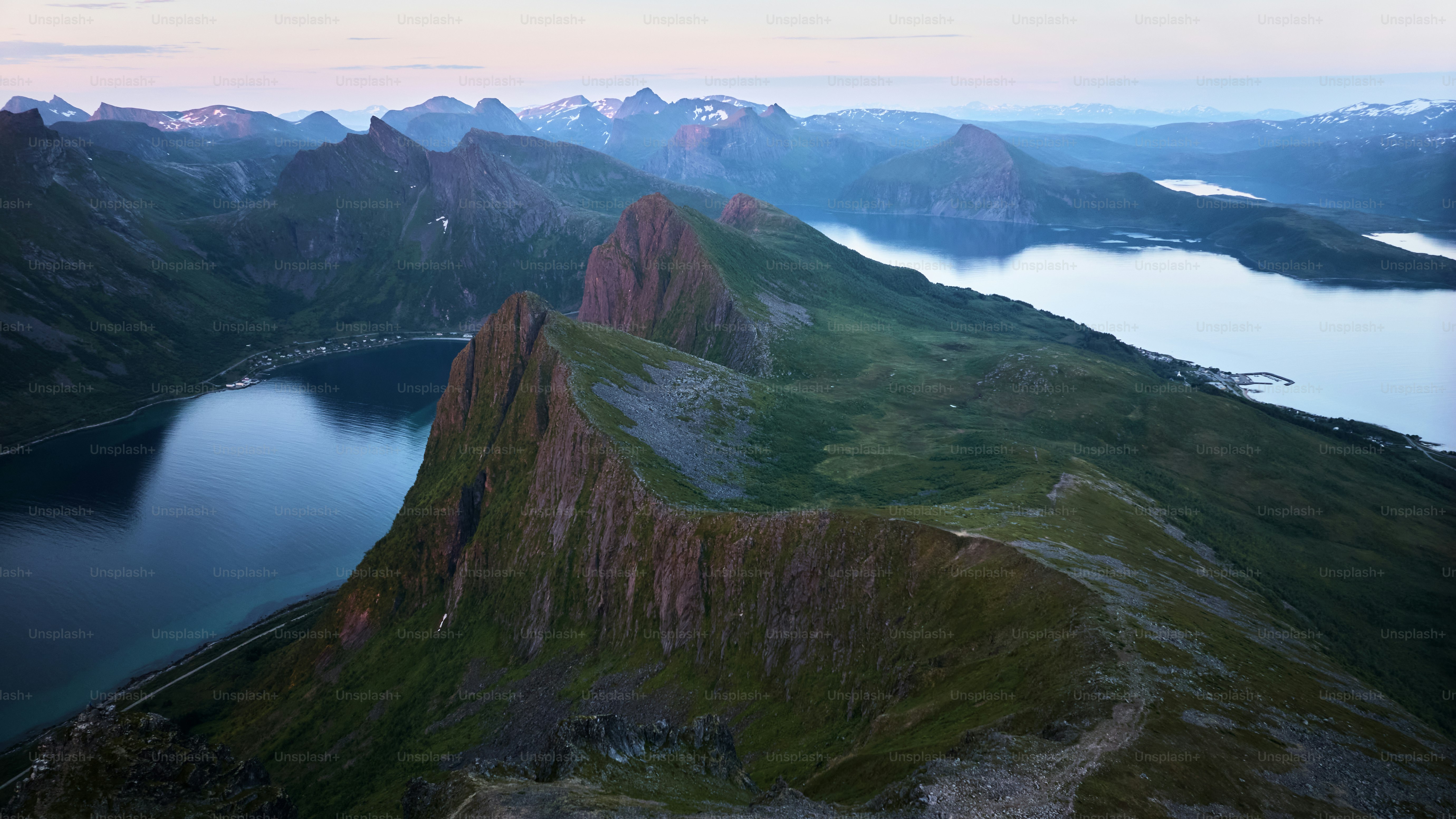 Gezackte Berggipfel mit Seen in der Dämmerung