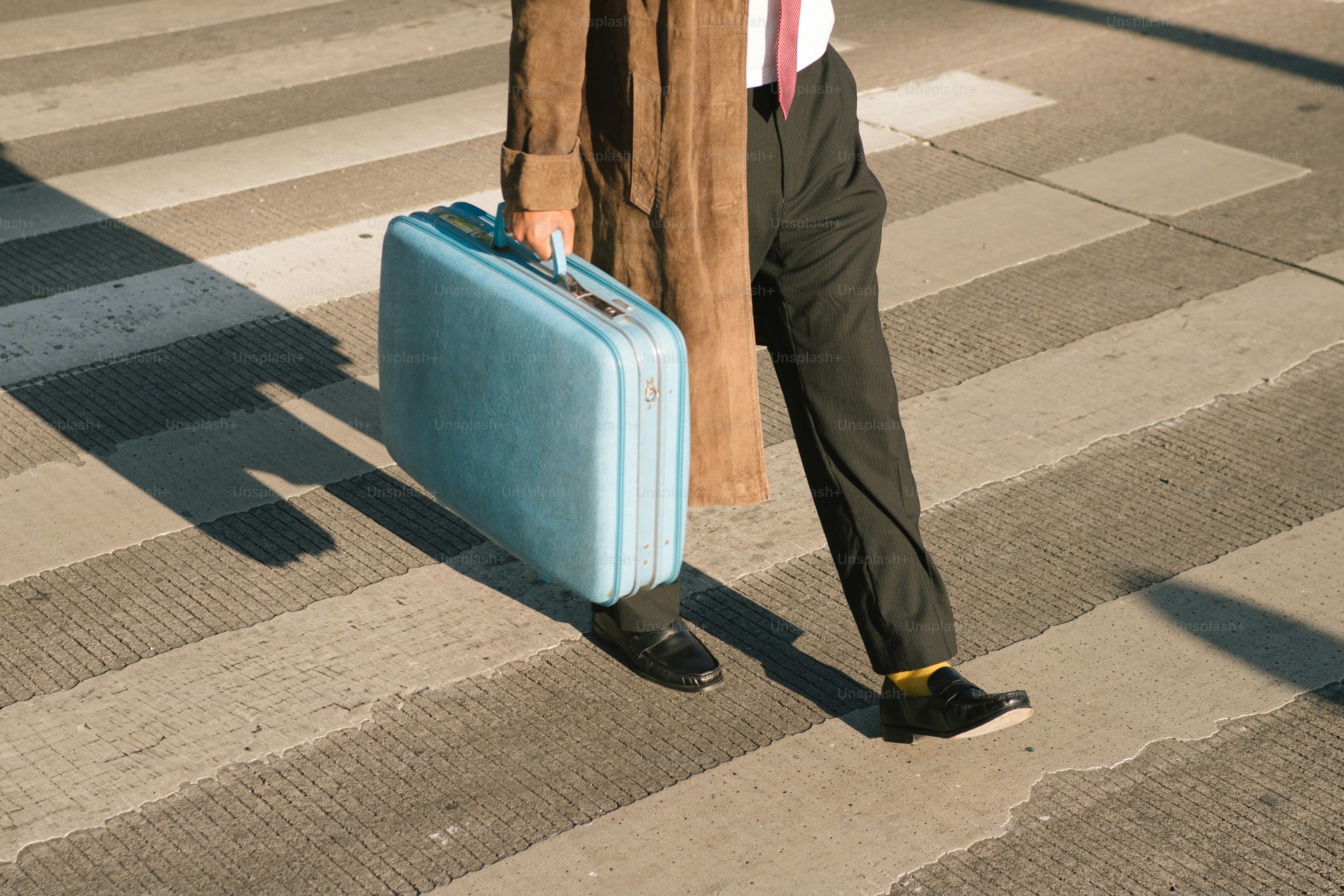 Un homme avec une mallette traversant une rue.