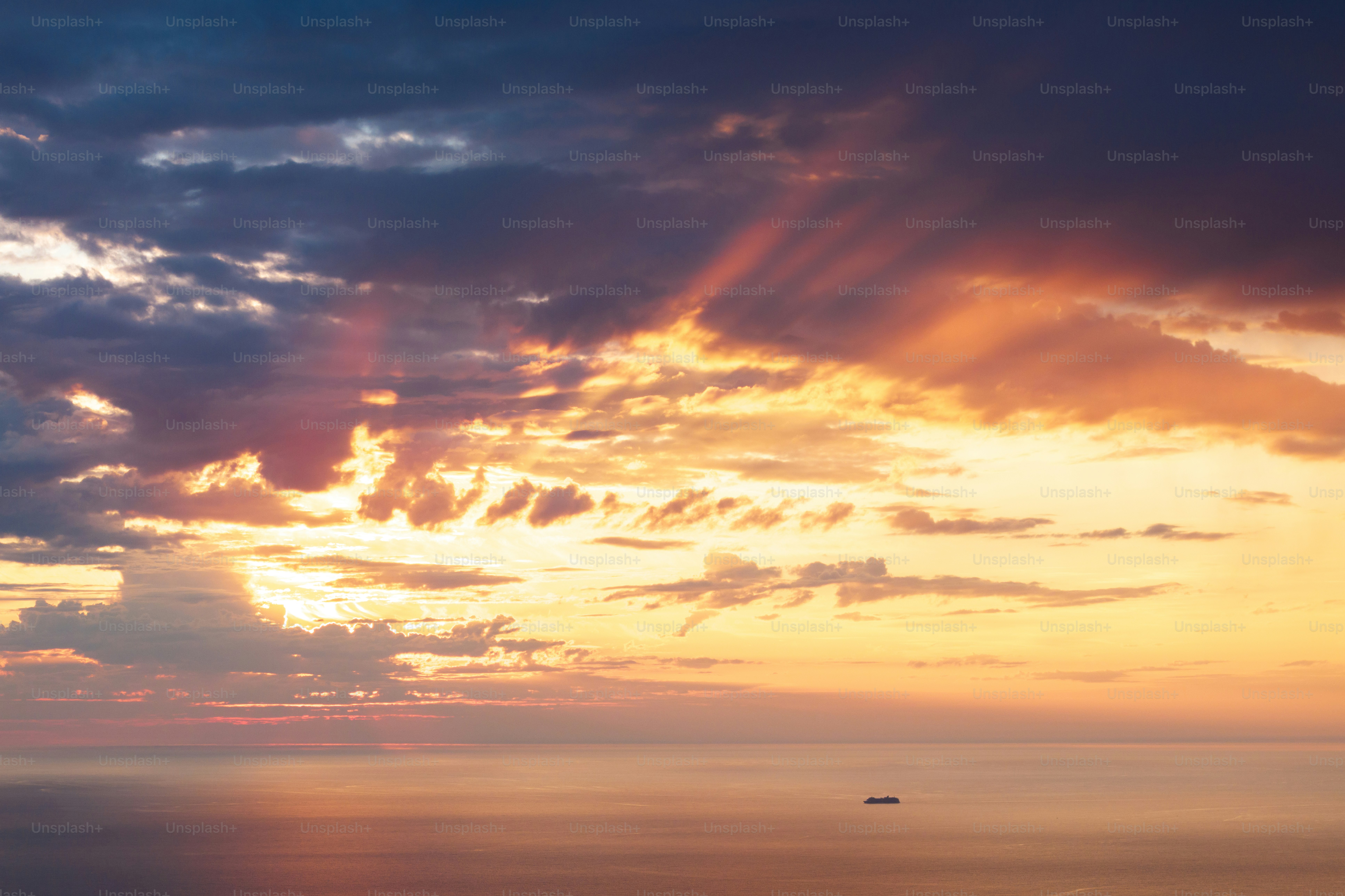 Dramatischer Sonnenuntergang mit Sonnenstrahlen über dem Ozean.