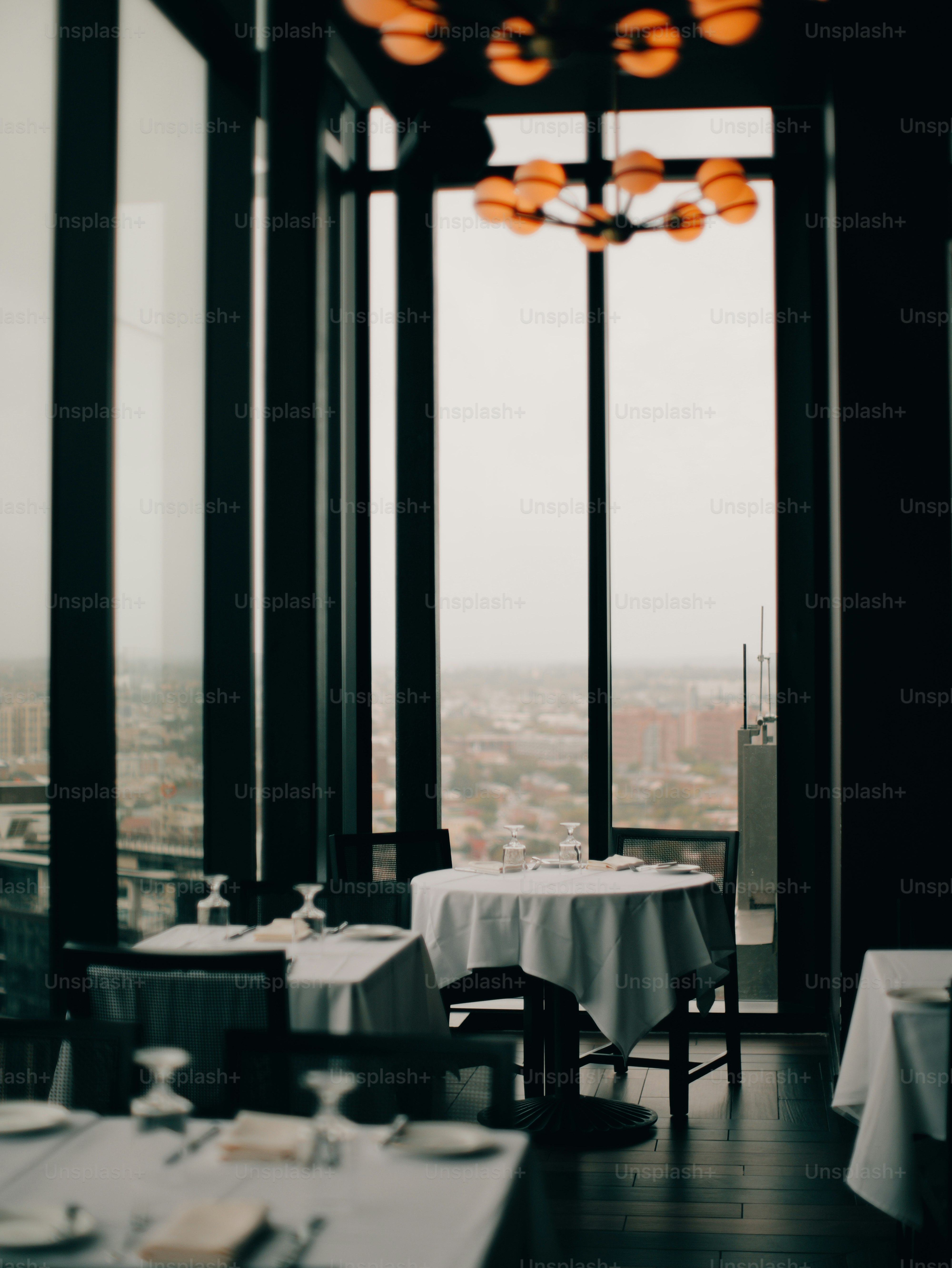 Elegantes mesas de restaurante ao lado de grandes janelas