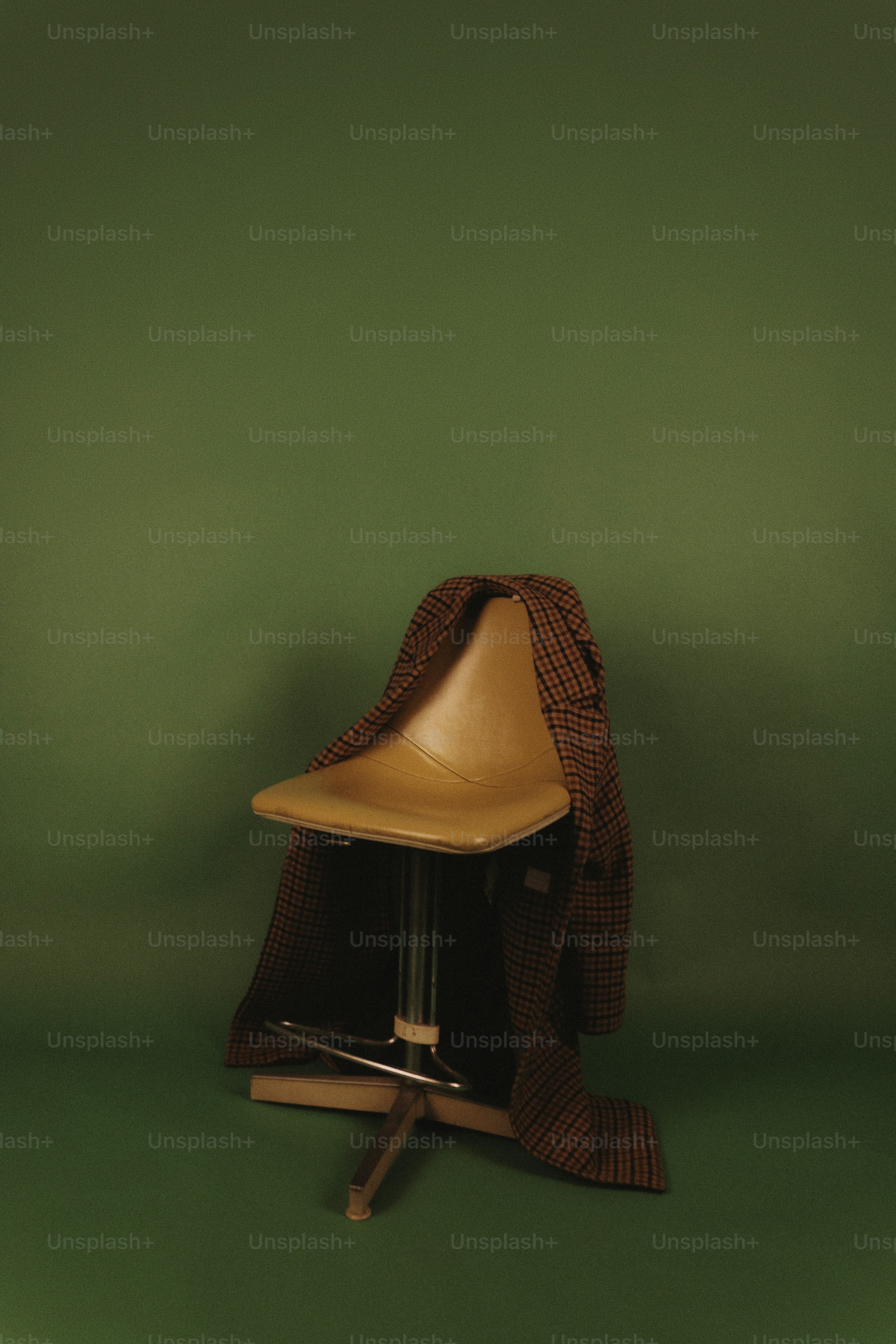 A chair with a blanket draped over it.