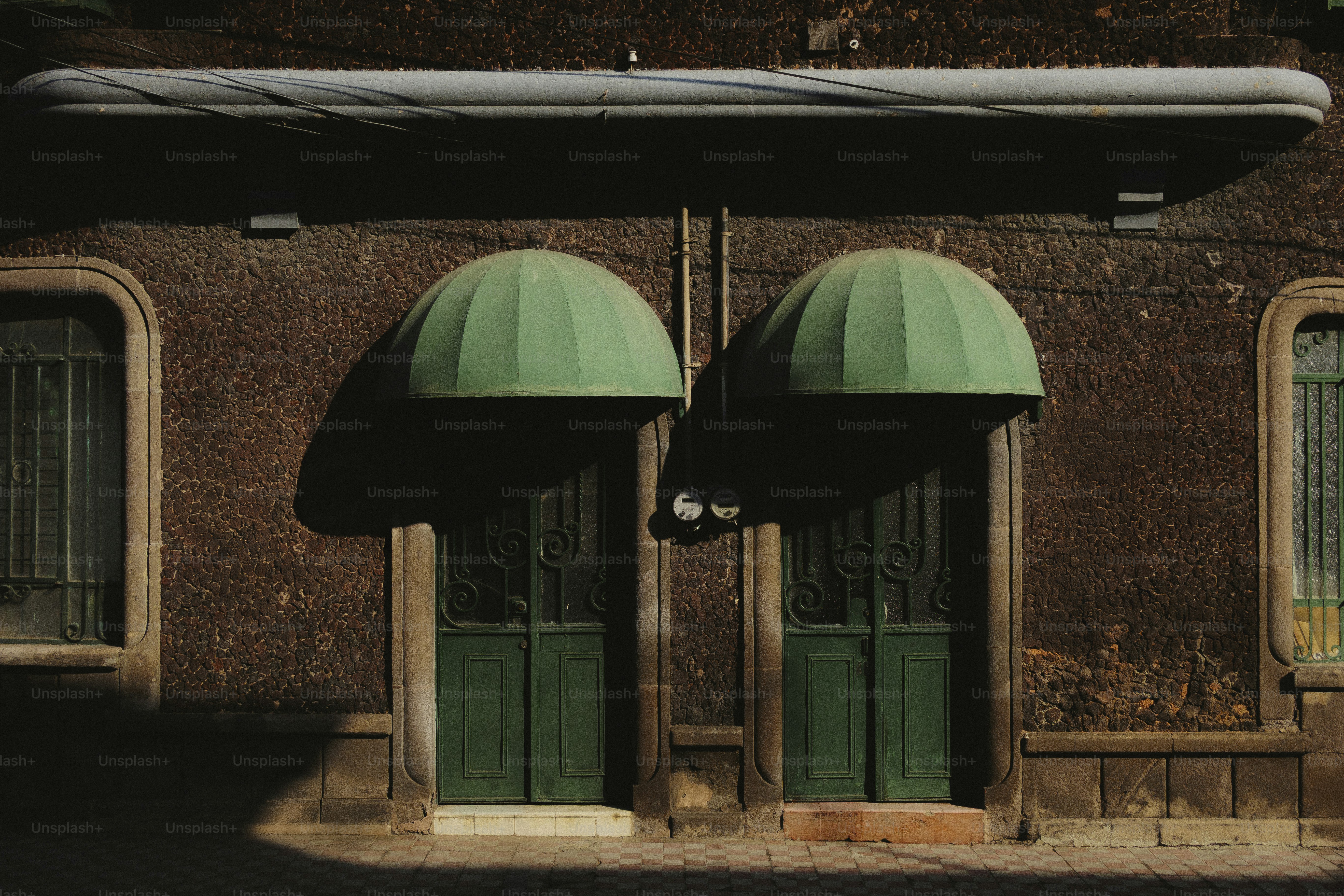 Dos puertas verdes con toldos en el edificio