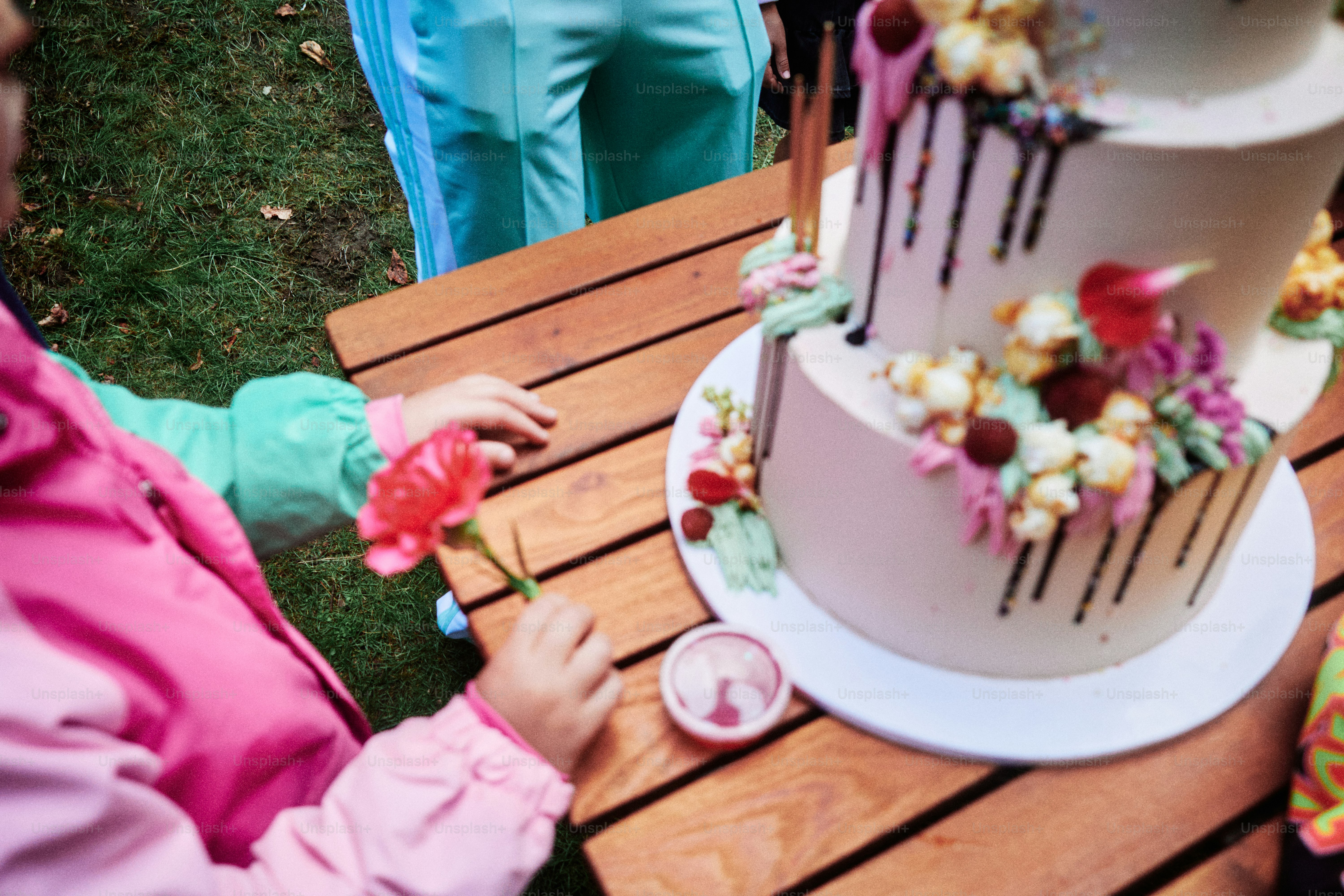 Enfant tenant une fleur près d’un gâteau d’anniversaire décoré