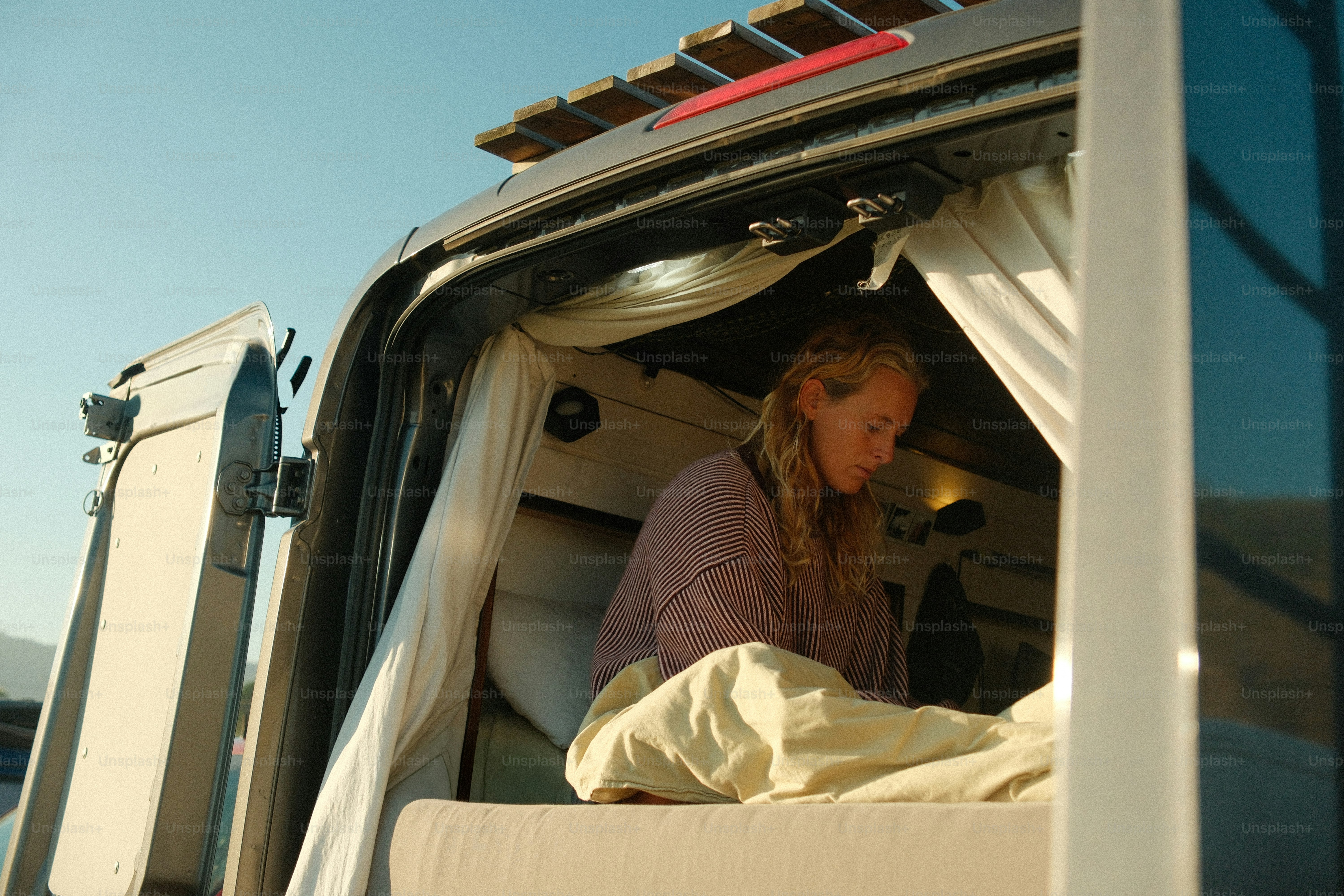 Mulher descansando dentro de uma van em um dia ensolarado