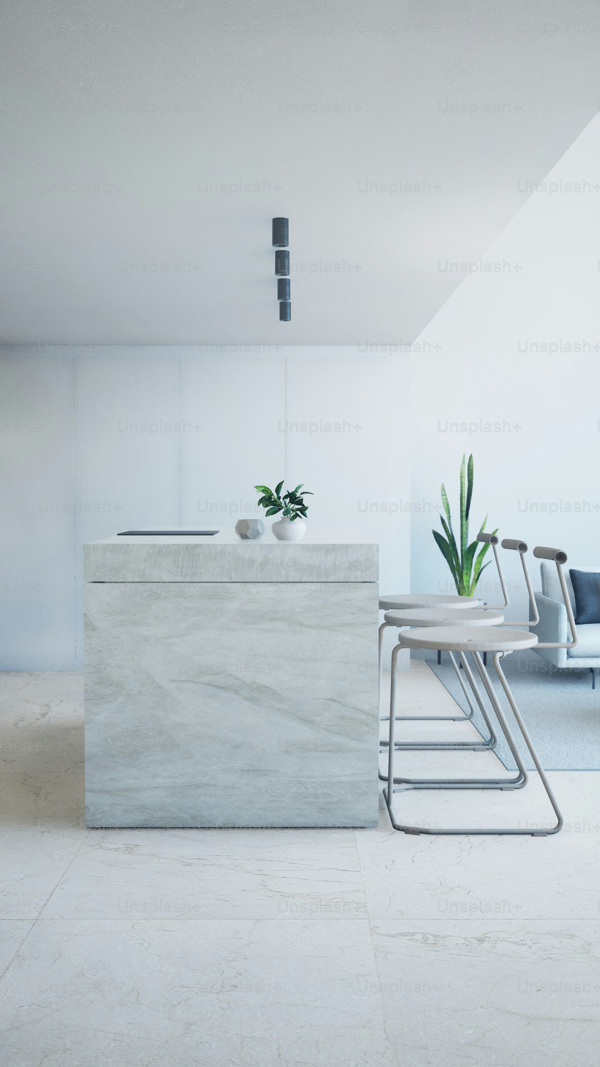 Modern kitchen island with stools and plant.
